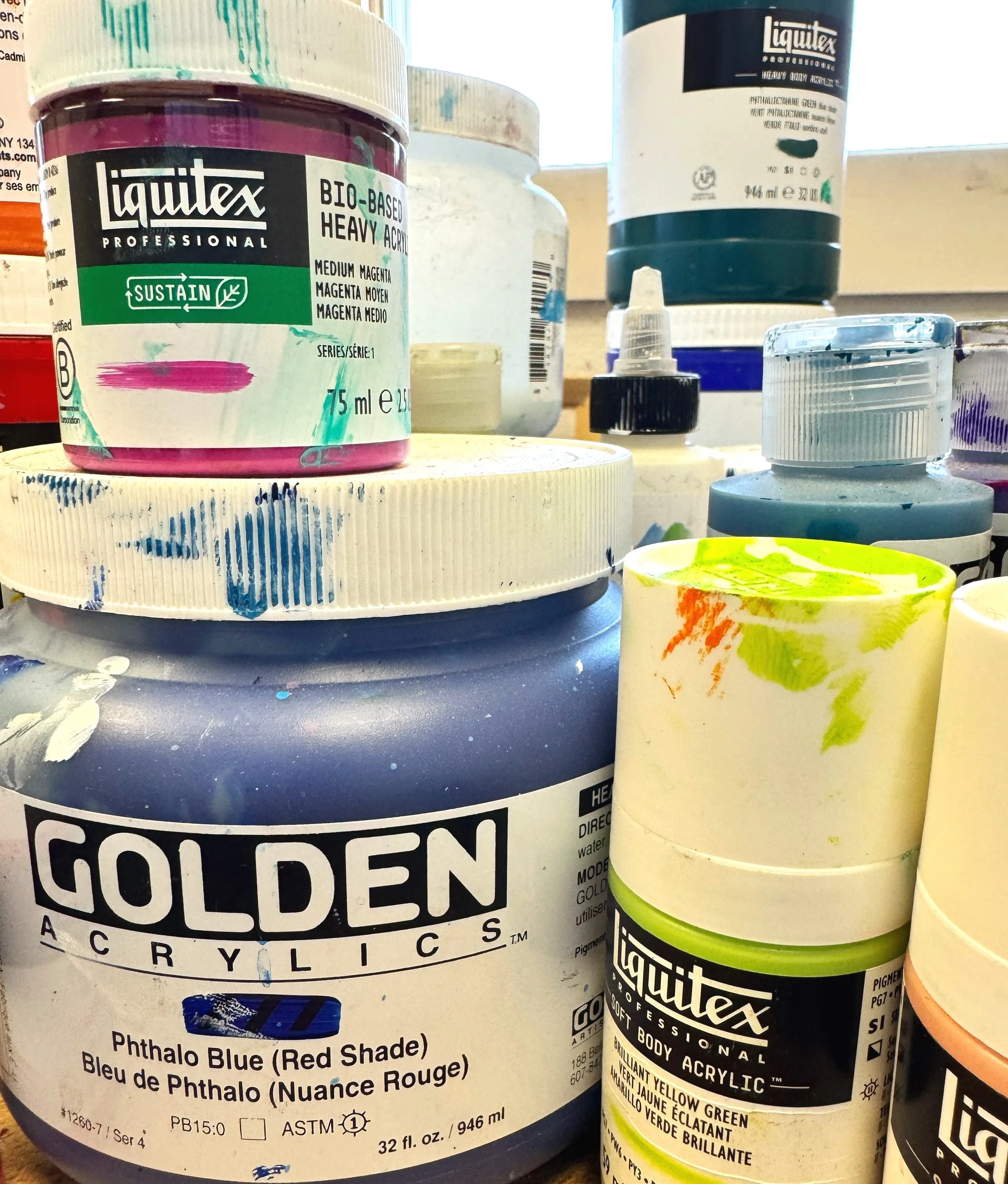 acrylic and water color paints in bottles and containers