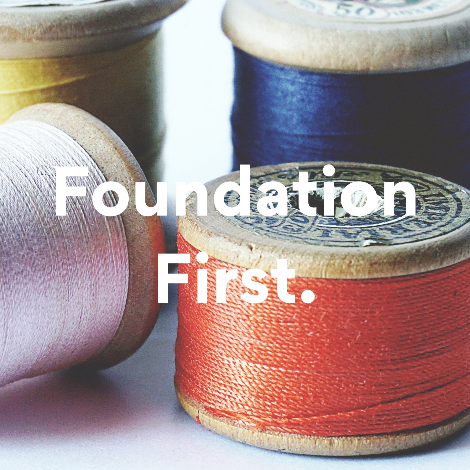 small, vintage spools of thread in orange, lilac, blue and yellow