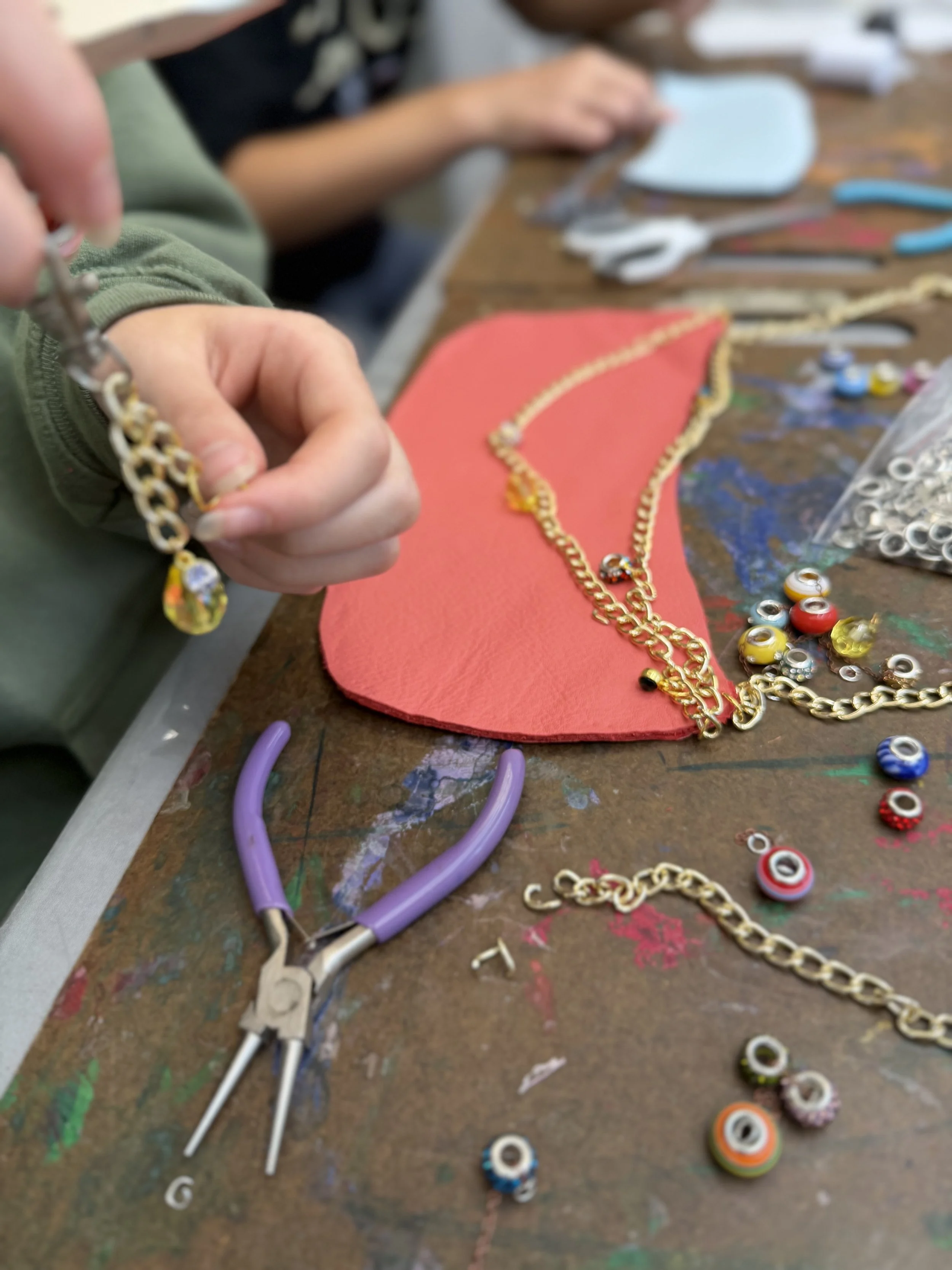 diy creation of a red leather bag, with pliers, jems and gold chains - work in progress