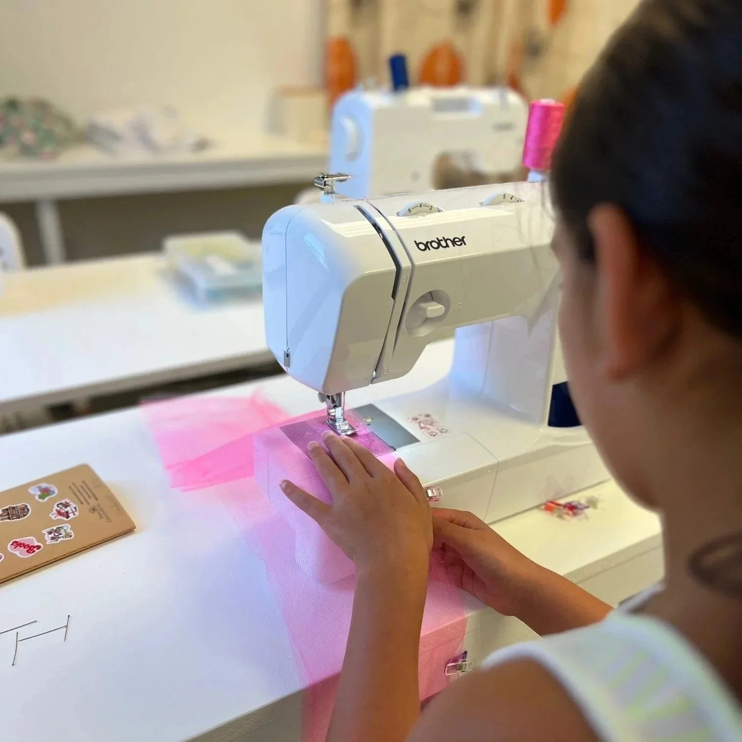 girl sewing fuchsia tulle on sewing machine