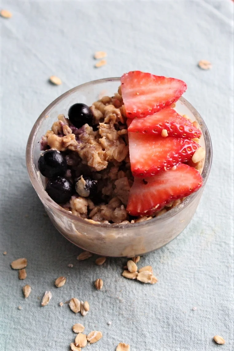 Hot oatmeal topped with fresh strawberries, frozen blueberries and peanut butter