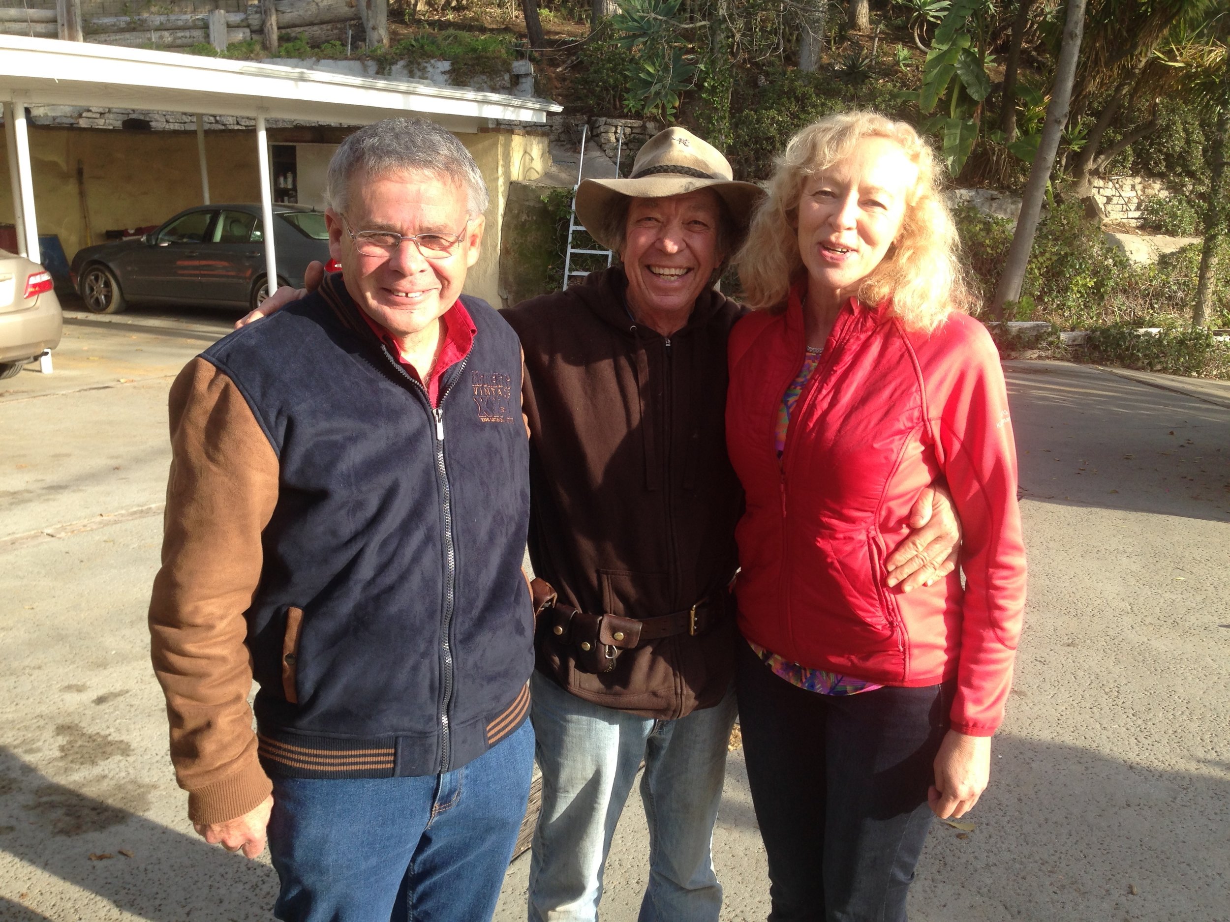 COLIN VISITS WITH NEIL AND HIS WIFE CHRIS, ON COLIN'S RANCH IN MALIBU . THEY ALL MET 30 YEARS AGO WHEN COLIN FIRST STARTED PESTERING NEIL ABOUT WRITING A BOOK. COLIN DIDN'T BUY NEIL'S EXCUSE THAT HE WAS NOT A WRITER. AFTER WORKING AT IT FOR A COUPLE OF YEARS, NEIL DISCOVERED HE WAS INDEED A WRITER AND TODAY HE HAS A RUNAWAY BEST SELLER!! RECALLS CHRIS: "COLIN, THERE WERE TIMES I WANTED TO KILL YOU! WRITING THIS BOOK WAS DRIVING US CRAZY. BUT NOW I JUST WANT TO HUG YOU FOR MAKING US DO IT. "