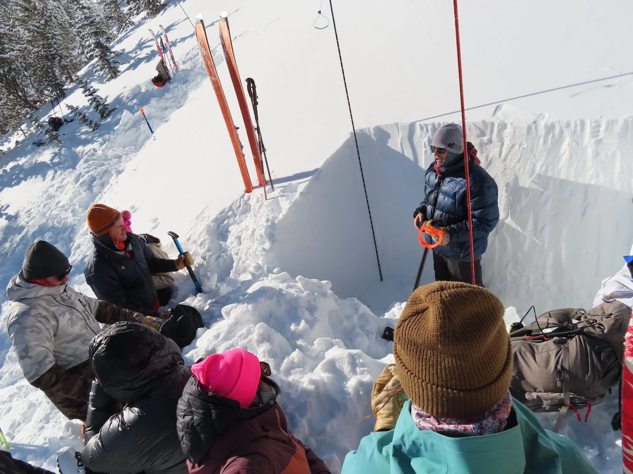 Avalanche course students gathered around snowpit