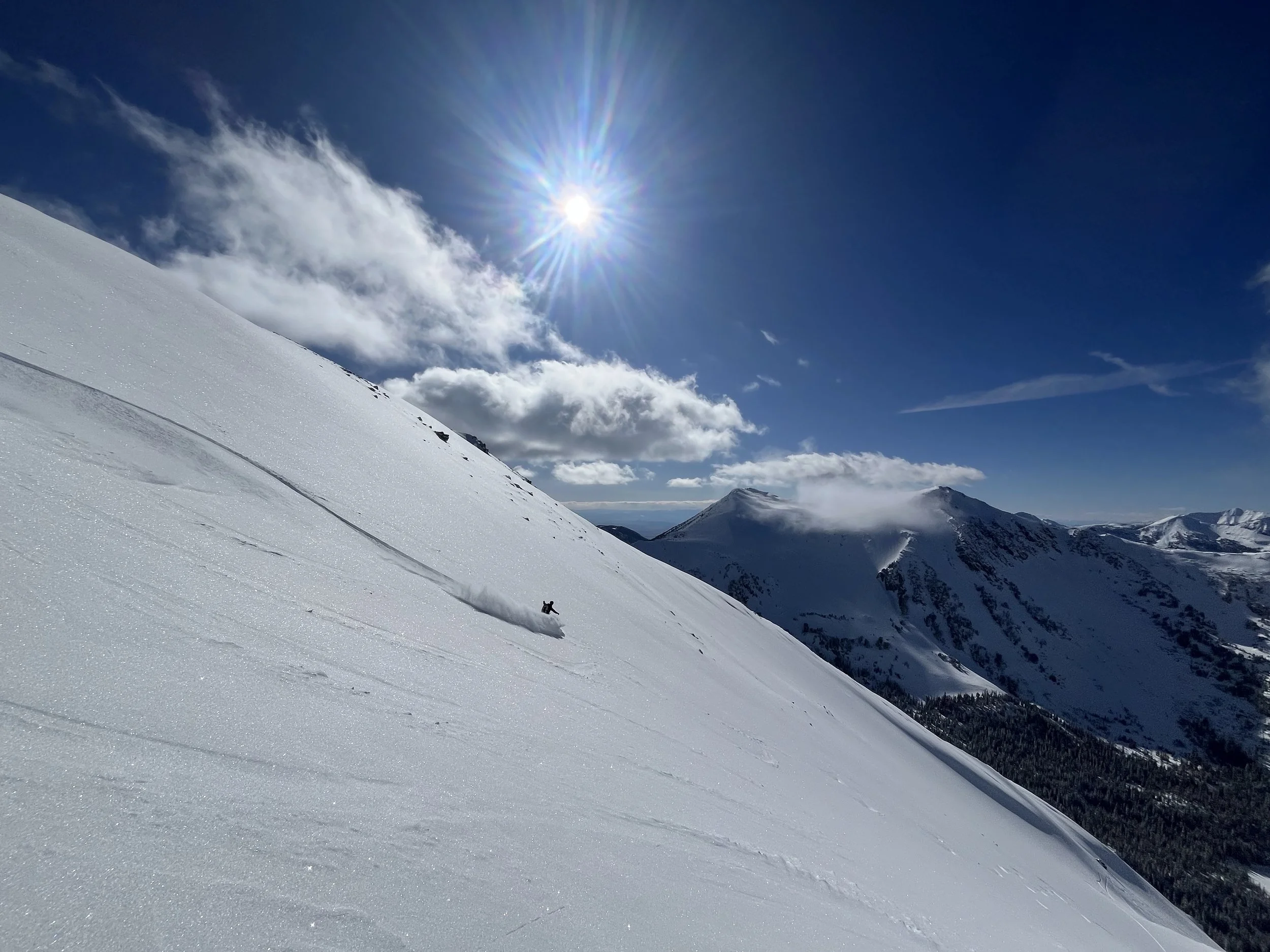 Backcountry skier with blue sky and sunshine