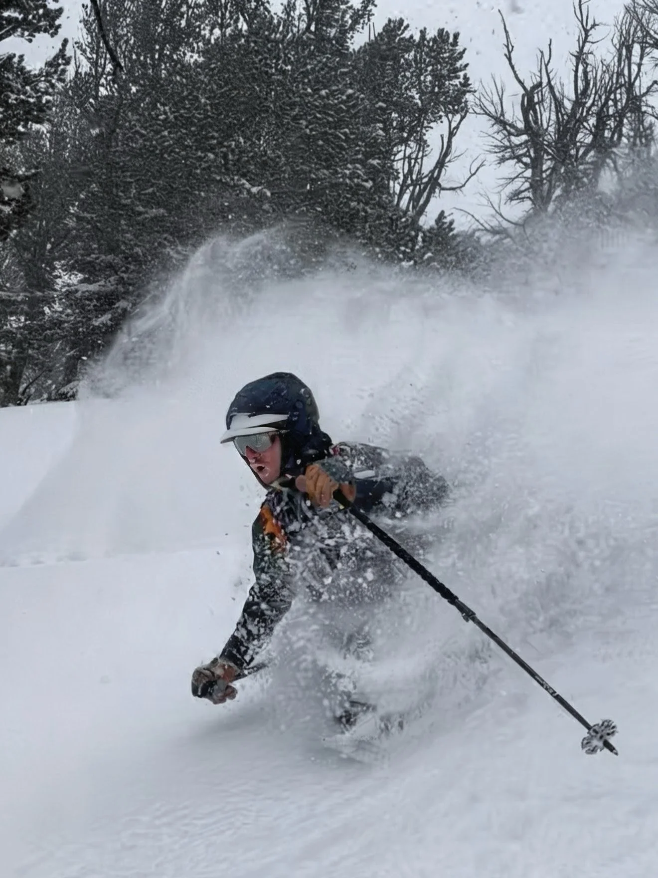 Skier in waist-deep powder at Bell Lake Yurt