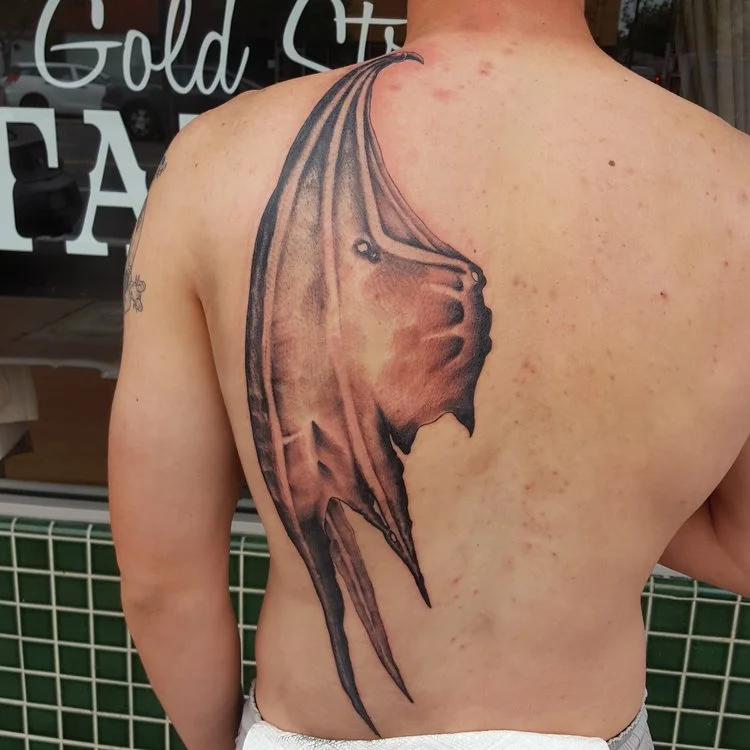 Devil wing black and gray on half back tattoo. 