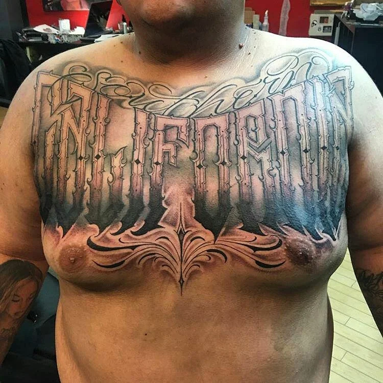 California block lettering on the chest black and gray tattoo.