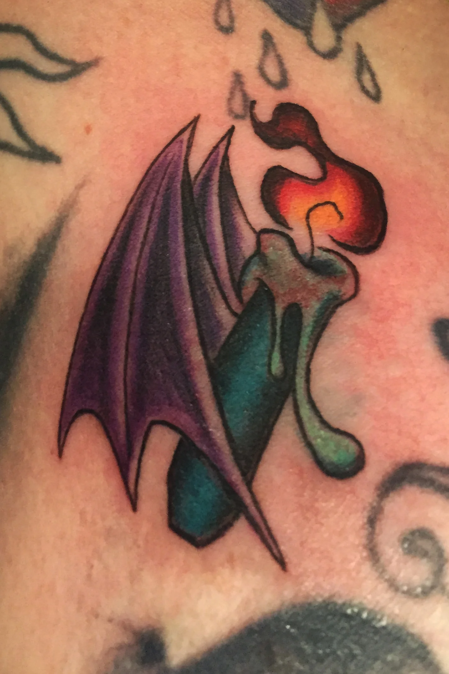 Burning candle with bat wings in color on the Collarbone. 