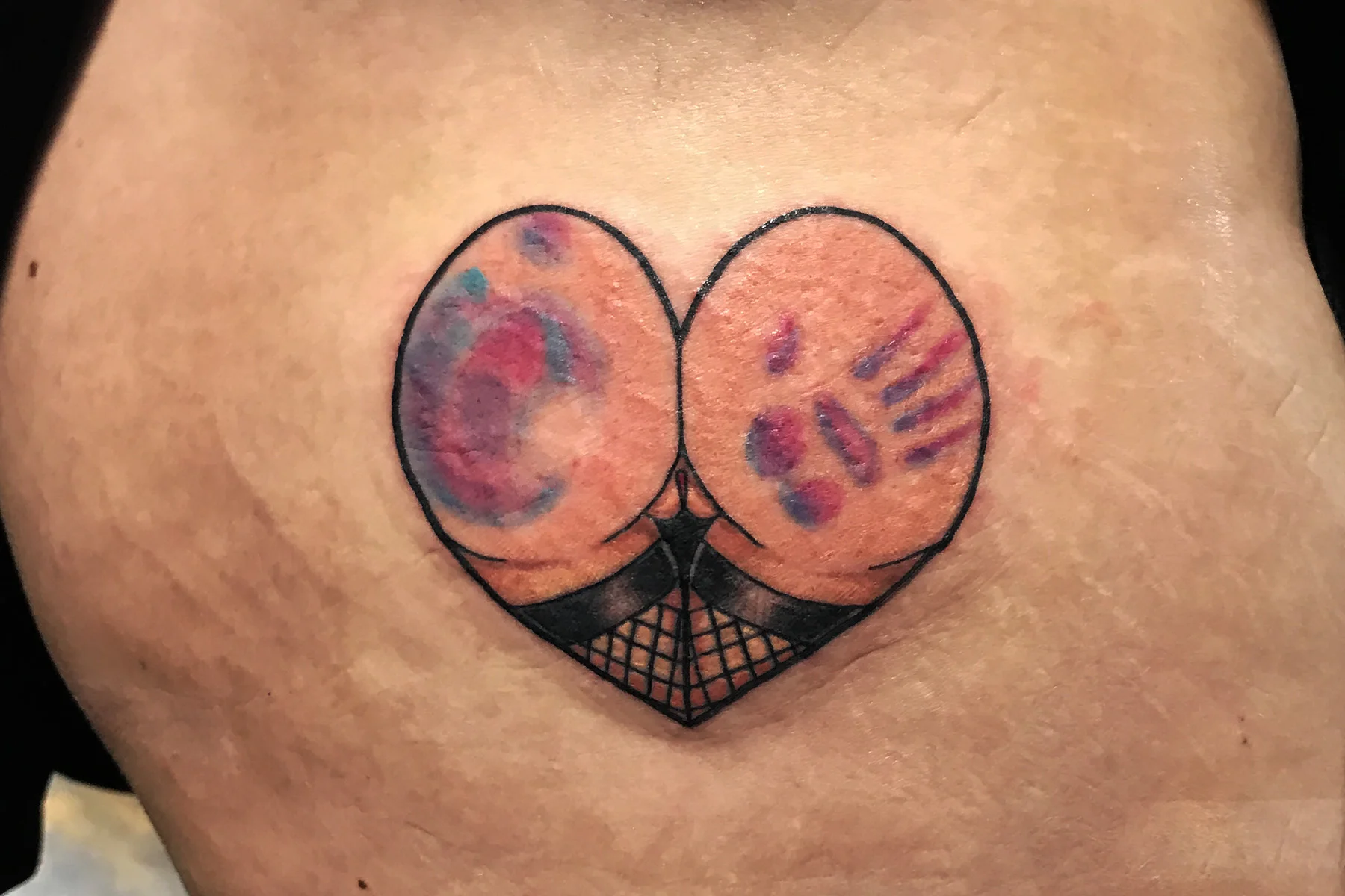 Heart butt tattoo wearing thigh high stockings and a hand print in color. 