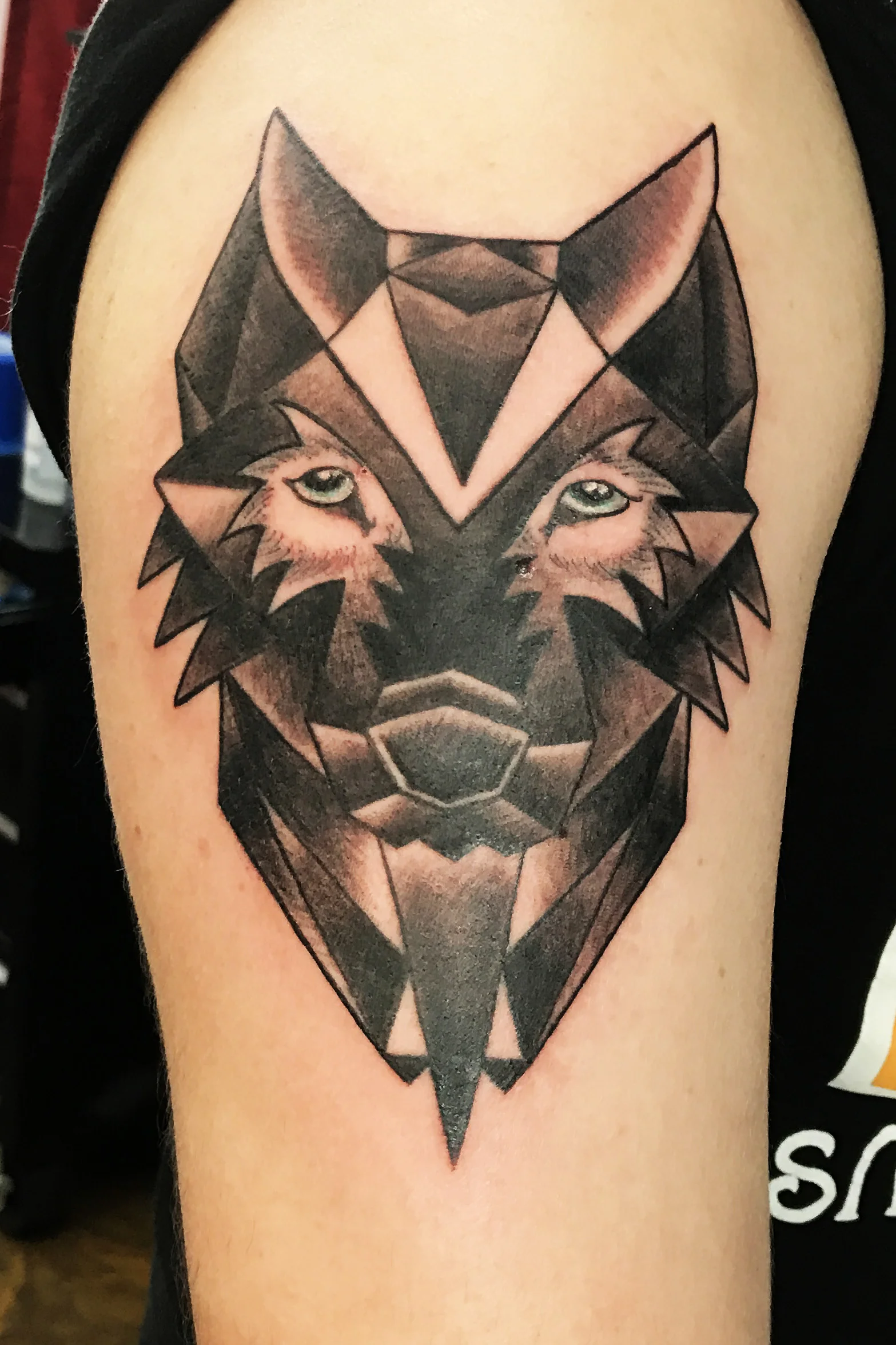 Geometrical Games of Thrones wolf, direwolves for the Stark family. Black and gray tattoo on upper arm half sleeve.