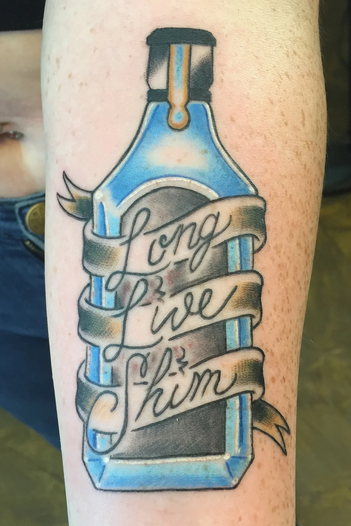 Bombay Sapphire gin memorial tattoo. Cursive lettering "Long Live Shin". Color forearm half sleeve tattoo. 
