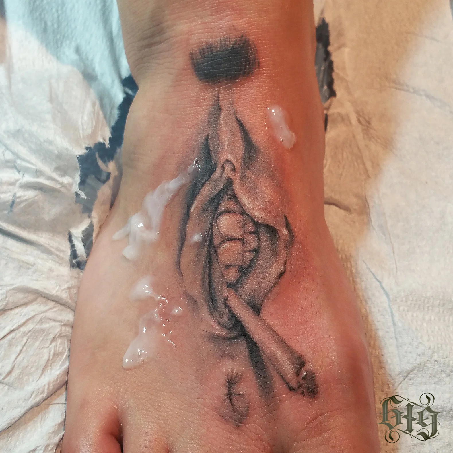 Black and white tattoo of a vagina on the top of a foot with teeth and smoking a rolled cigarette. 