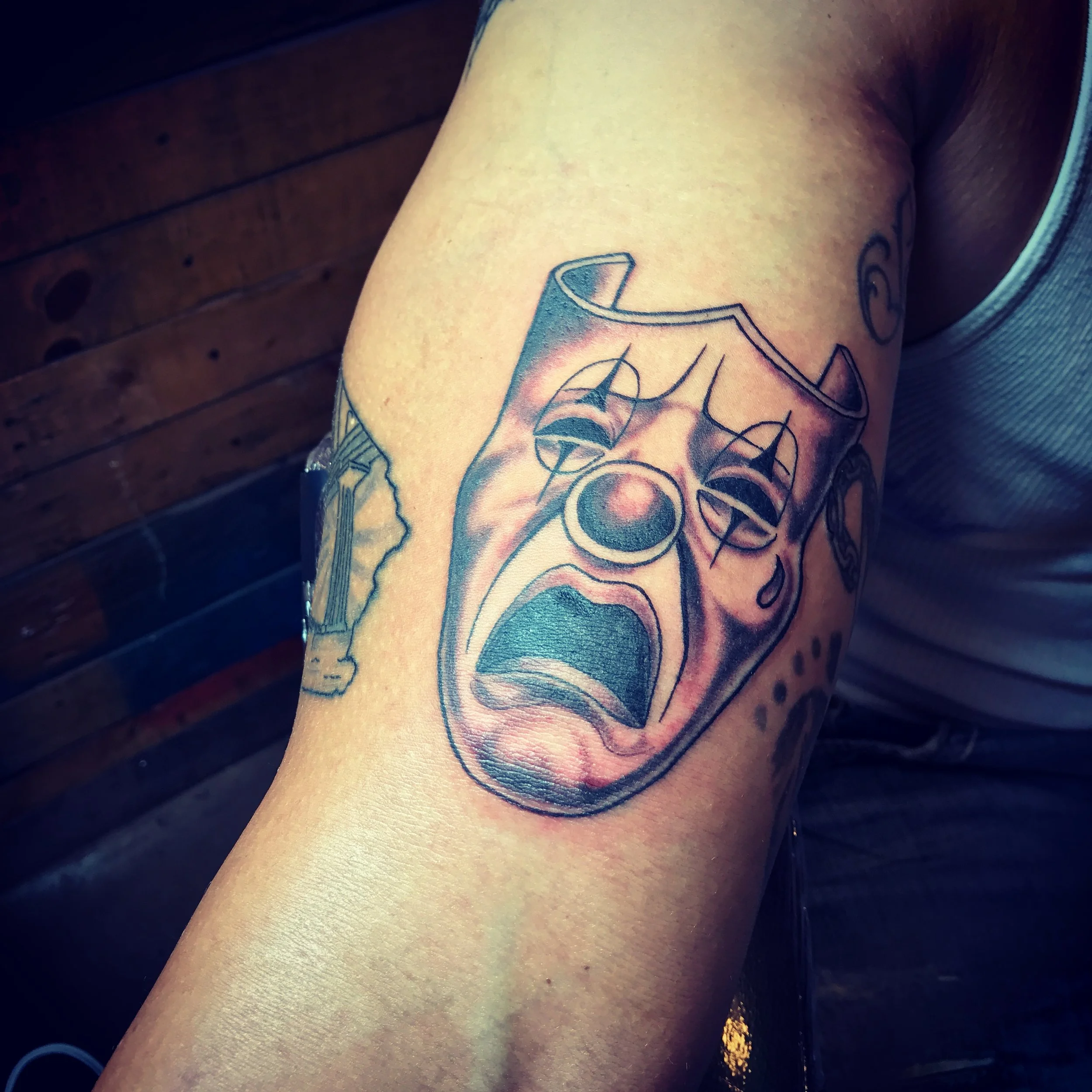 Black and gray upper arm half sleeve Theater Mask "Sad" Tattoo.