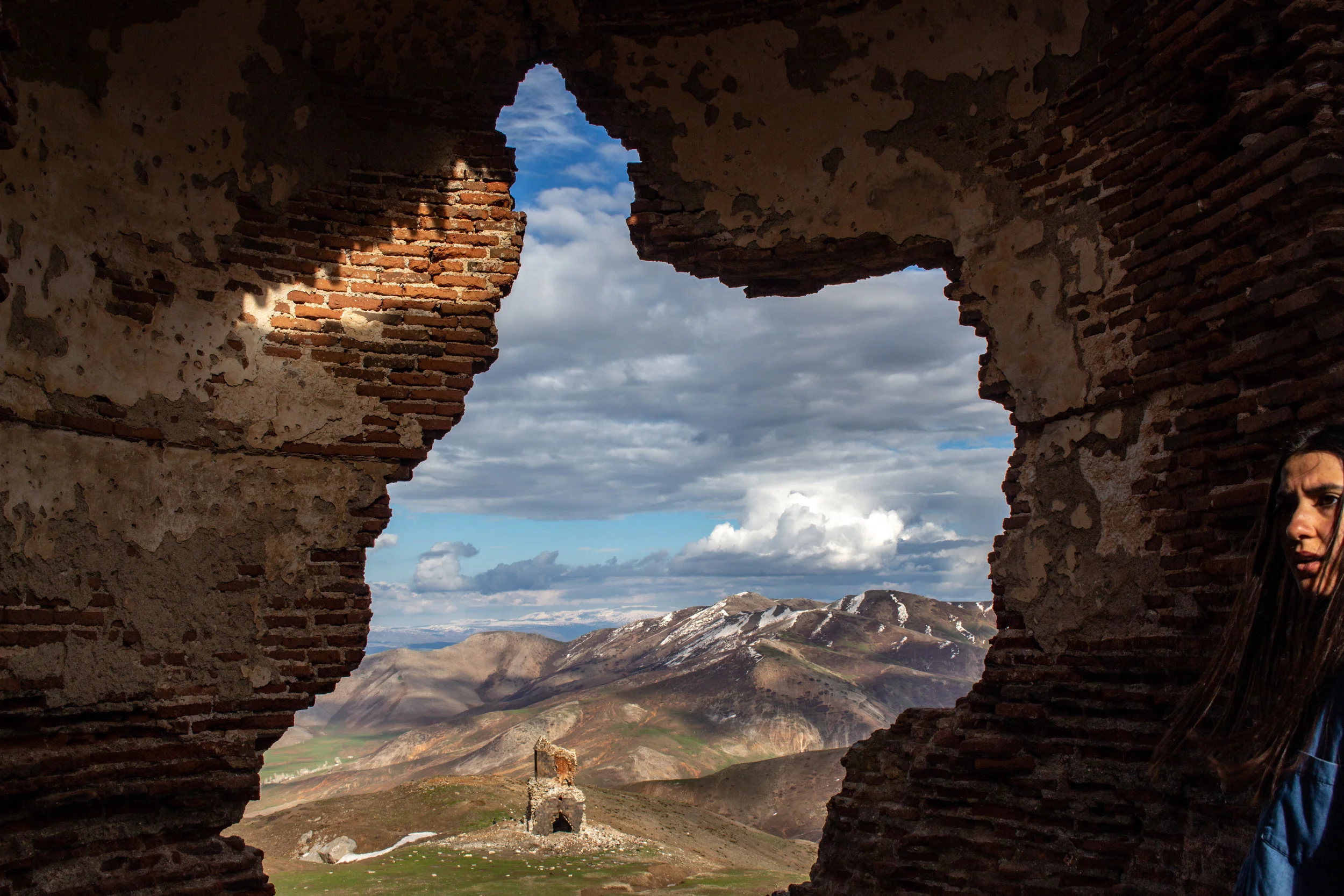 Standing on what should be the altar of Arakelots Monastery's main church, the large void in its back wall gives way to a view of the ruins of Saint Thaddeus Church, and the vast landscape Armenians had called home since the time of Menua - the king of Urartu in 800 BC - whose cuneiform inscriptions were found in the vicinity. The monastery itself was founded in the early 4th century, became a major center of learning during the 12th-13th centuries, and remained one of the prominent monasteries of Western Armenia until the genocide in 1915. The indigenous Armenian population of the Taron (Muş) region - approximately 140,000 men, women, and children - were murdered. The whole of the structure remained standing until the 1960's, when it was blown up by the Turkish government. The innately carved double doors of Arakelots Church date back to 1134 and are considered one of the greatest masterpieces of Medieval Armenian art. The Mush Homiliarium, handwritten in 1200, is the largest surviving Armenian illuminated manuscript known - weighing over 60 pounds, with over 600 pages. In order to save the manuscript during the genocide, the book was divided in half and carried from the monastery to safety by two Armenian women fleeing their homelands. They are now both housed in Yerevan; at the History Museum of Armenia and Matenadaran - the Mesrop Mashtots Institute of Ancient Manuscripts. Armenians are still known to make the pilgrimage to the ruins of Arakelots, over a steep mile that climbs from the village at the base of the mountain to its peak, on their hands and knees.