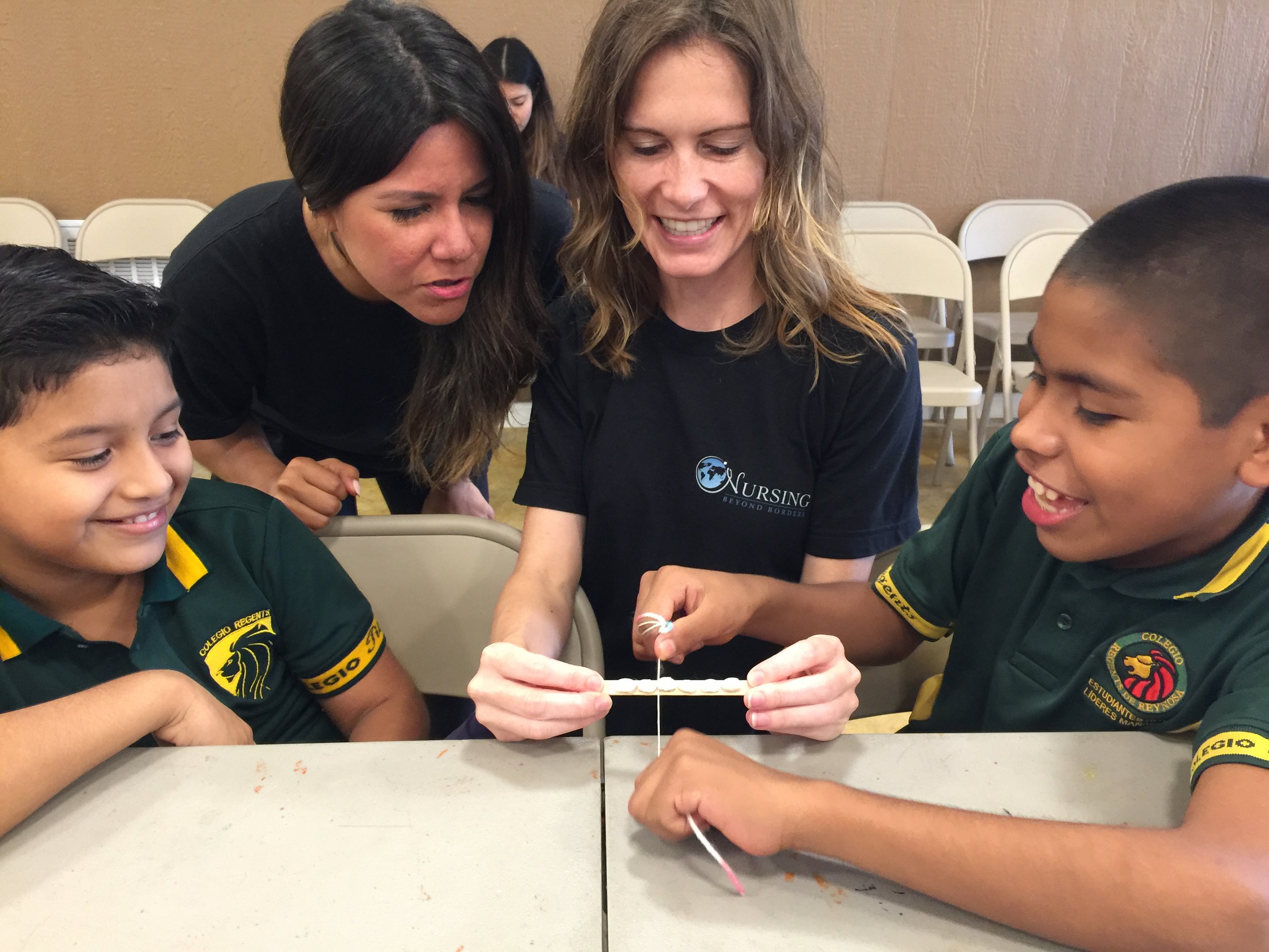  Practicing flossing with white beans, popsicle sticks, and yarn! 