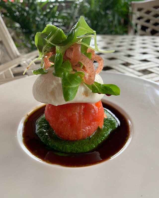 Burrata and oil poached tomato, arugula pur&eacute;e, pickled onions and aged balsamic vinegar.