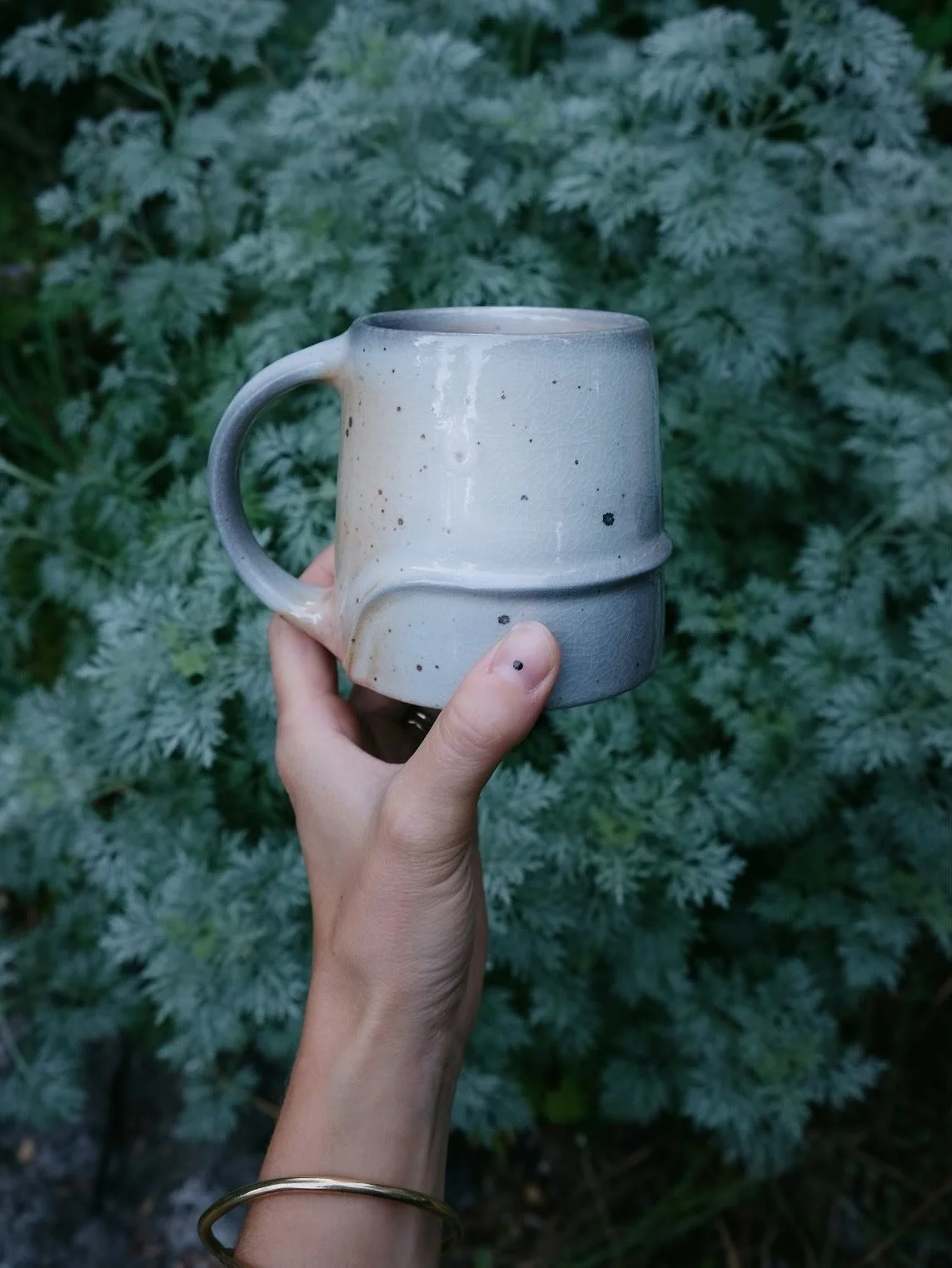 I made four of these. One cracked when I stamped the bottom and one developed glaze defects in the firing, so now there are two. 
Shino glaze with manganese and iron wedged into the clay for the speckles🖤
