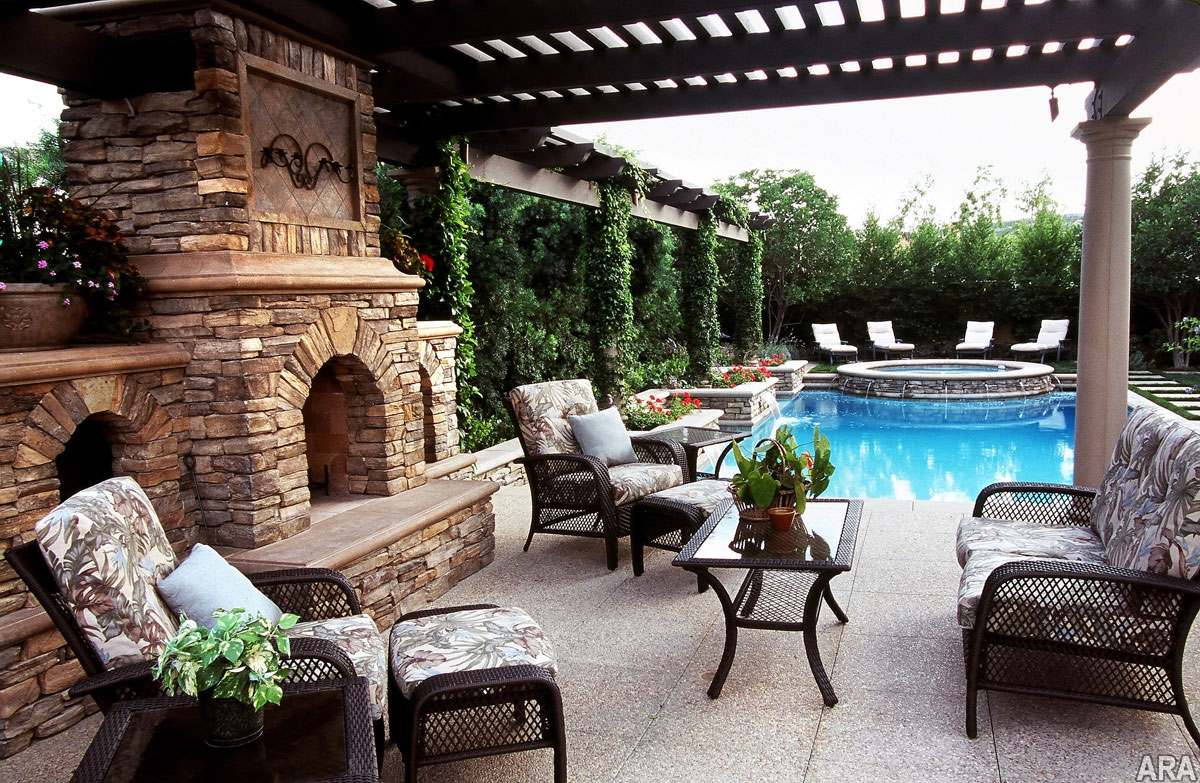 Backyard patio design with pergola and natural stone fireplace