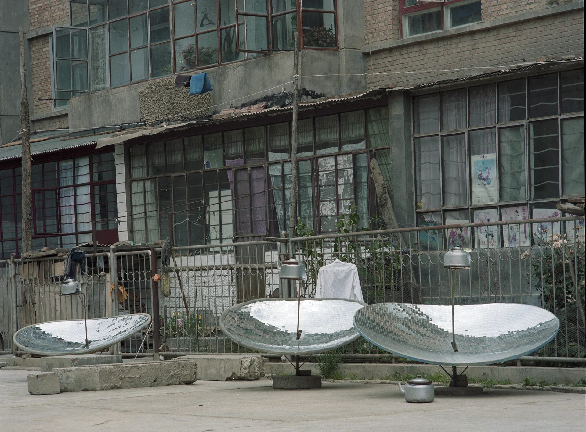 2007 Qinghai - solar watercookers in from of a Tibetan housing block in Tongren.