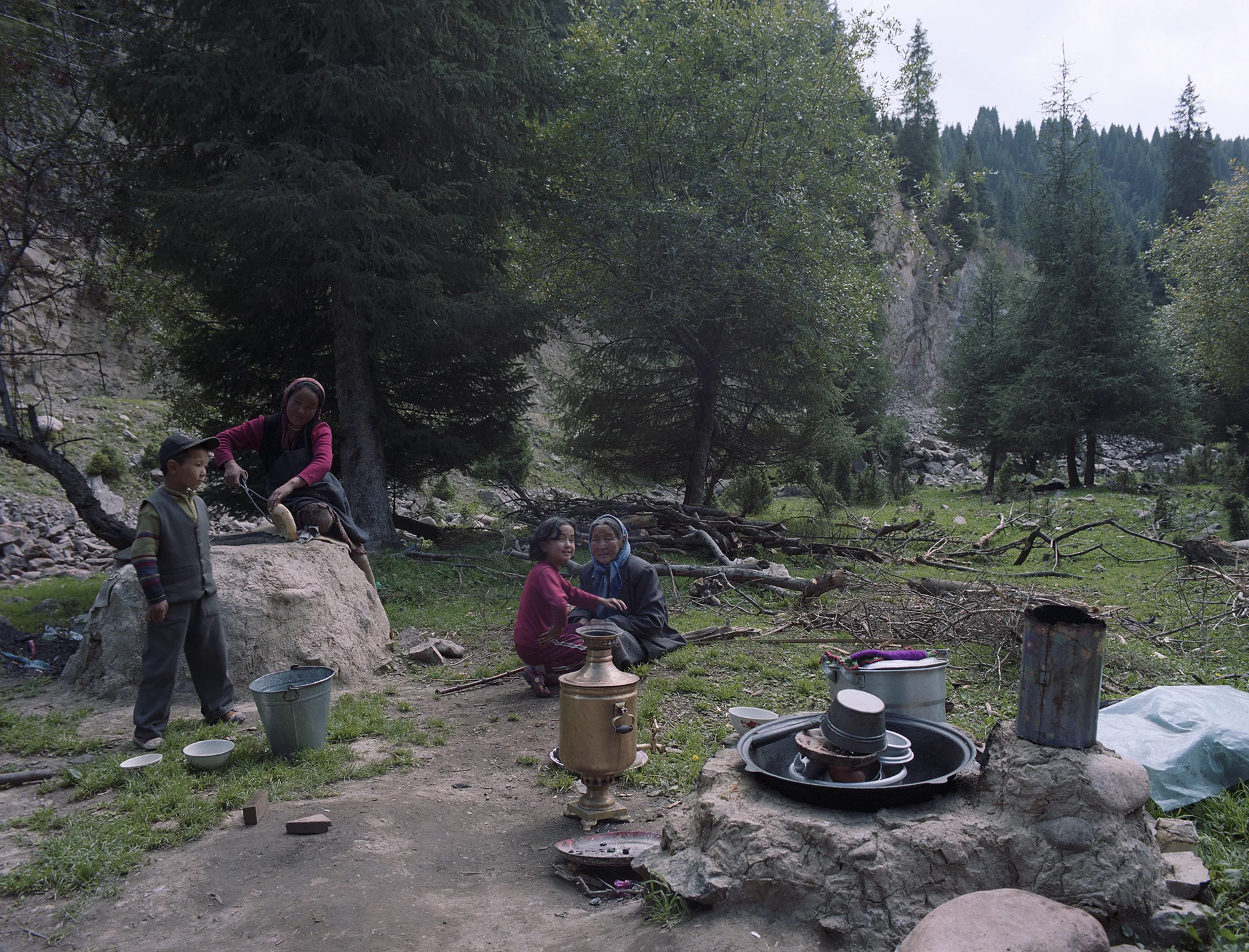 2007 Xinjiang - around the yurt with the family. The girl left id baking bread in the traditional stove built from local stones and mud.