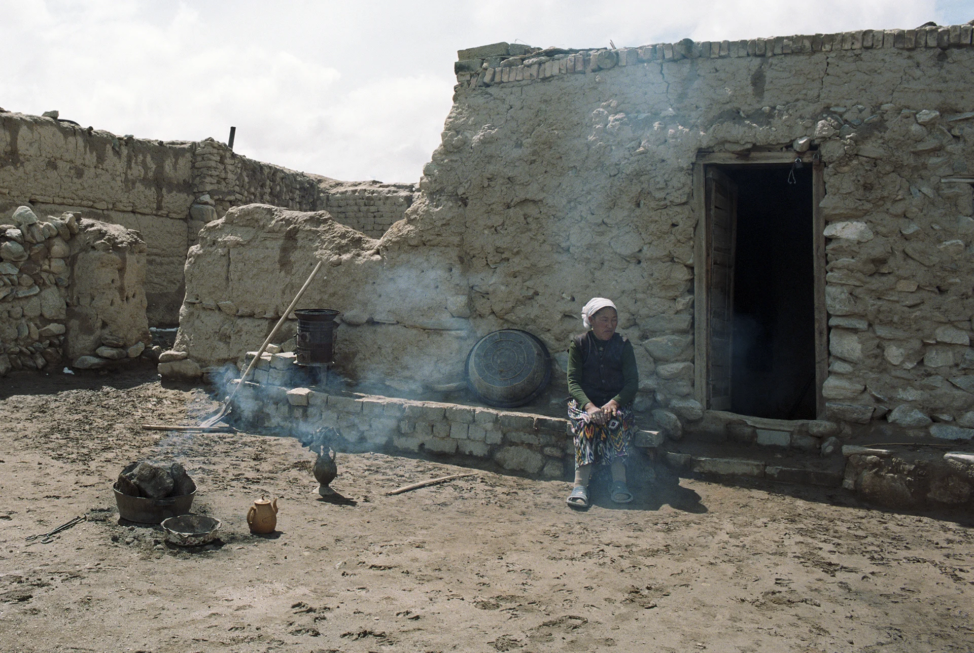 2007 Xinjiang - woman out in her yard to oversee the baking of the bread.