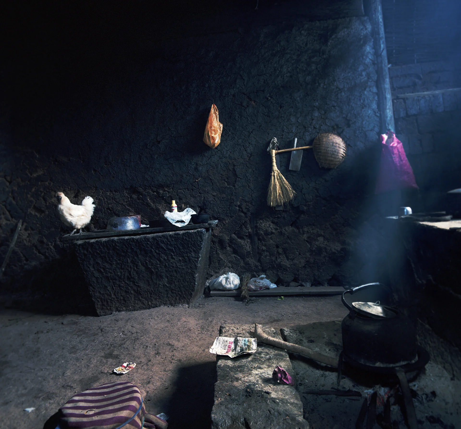 2008 Yunnan - a white chicken in a very black kitchen.