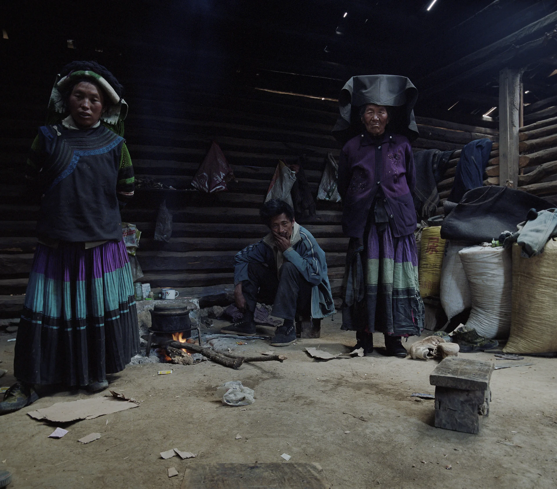 2010, in the vicinity of Lugu Lake - a Yi family in their home. This is their daily costume. No tourists come this far into the mountains.