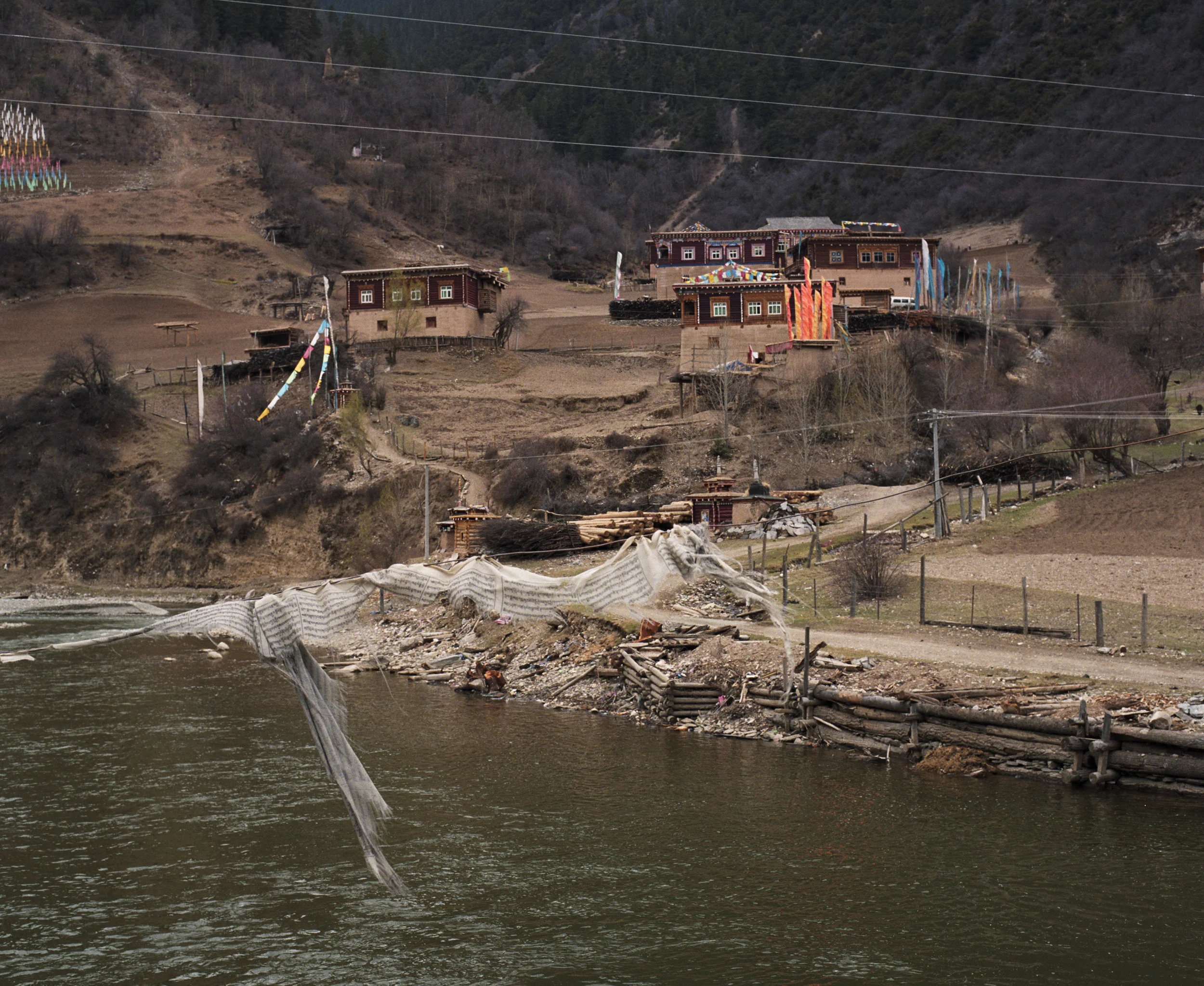 2010, Xinlong - a vilage at the other side of the river. Payer flags on a rope over the water.