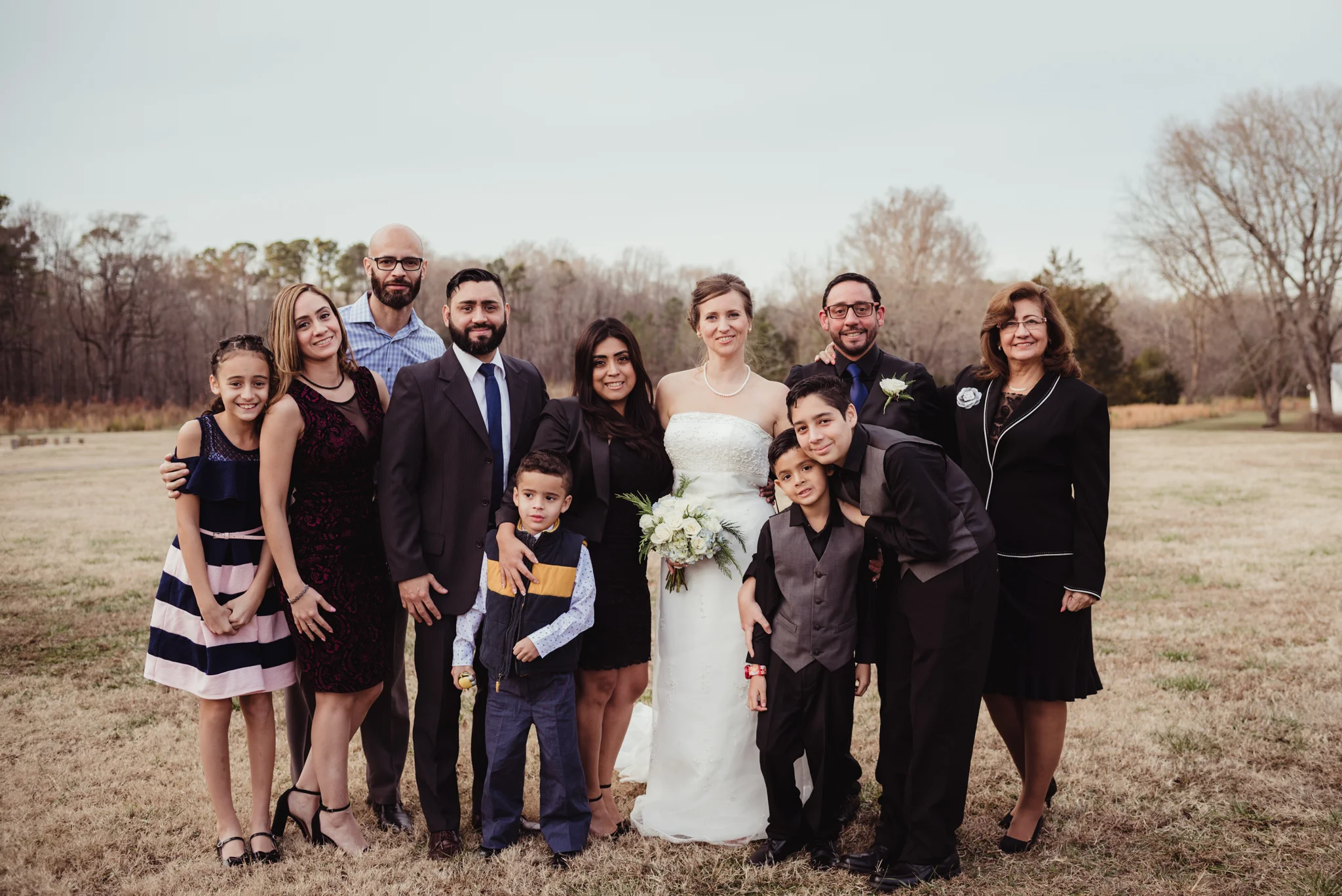 the-bride-and-groom-with-the-grooms-family-in-the-park-in-Raleigh.jpg