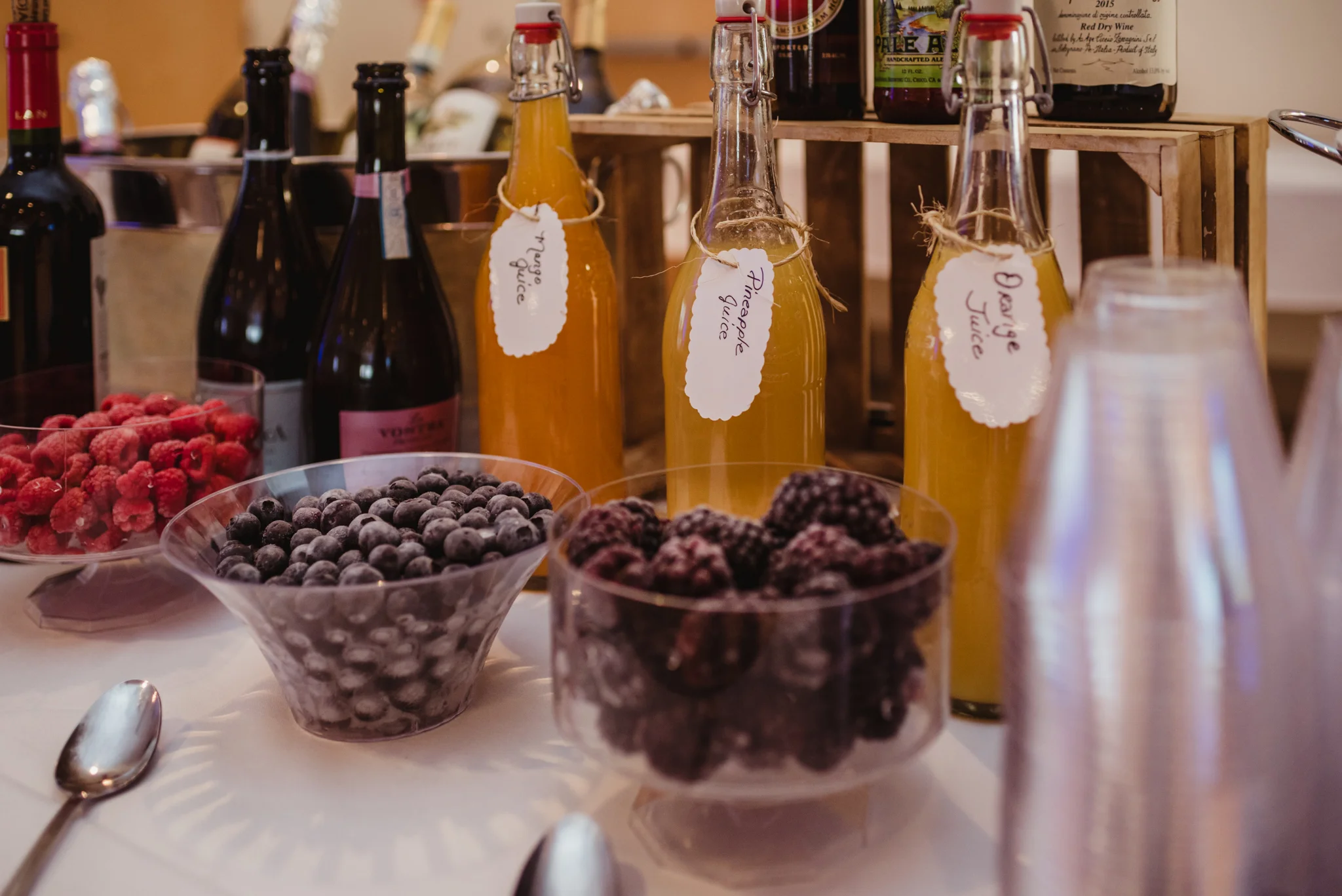 Raspberries, blueberries, and blackberries adorn the table with orange juice, pineapple juice, and mango juice to create mocktails for the kids celebrating Noah's bar mitzvah at Temple Beth Or.