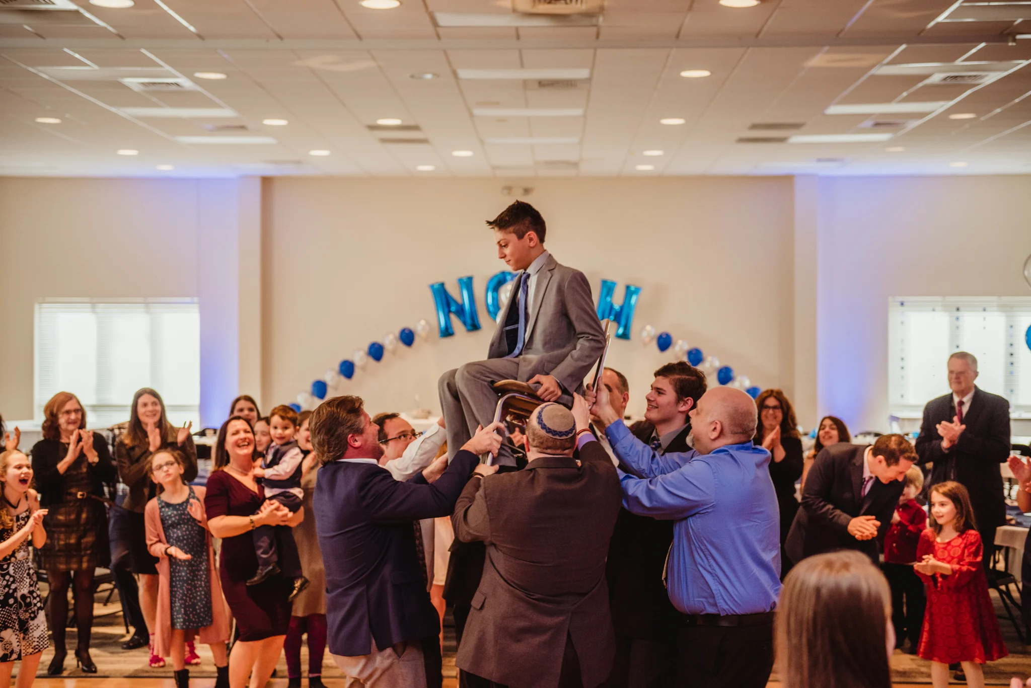 Noah is up high on his chair during the hora part of the bar mitzvah celebration.