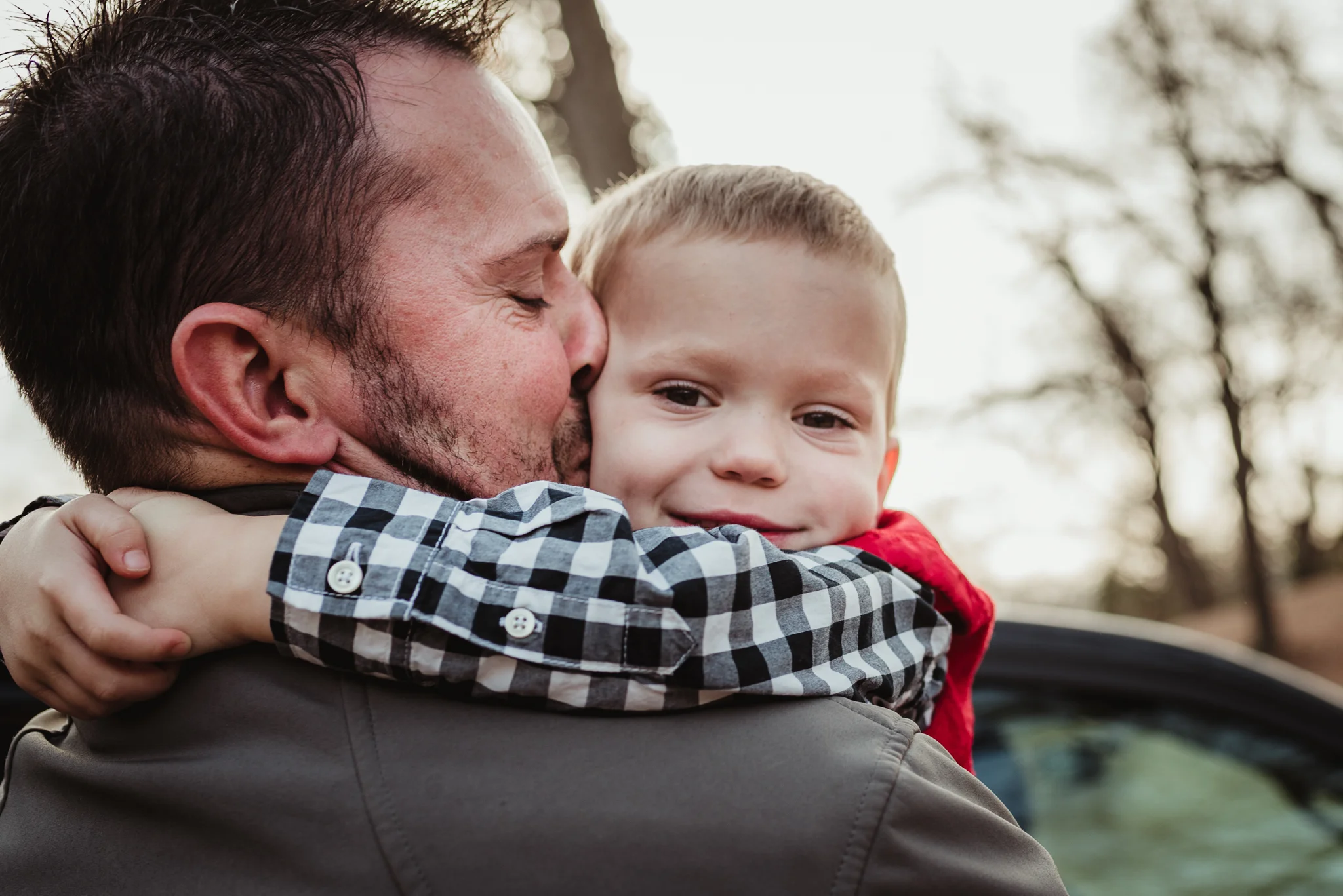 Dad giving his three year old son a kiss as they get ready for family photos at Dorothea Dix Park in Raleigh, North Carolina.