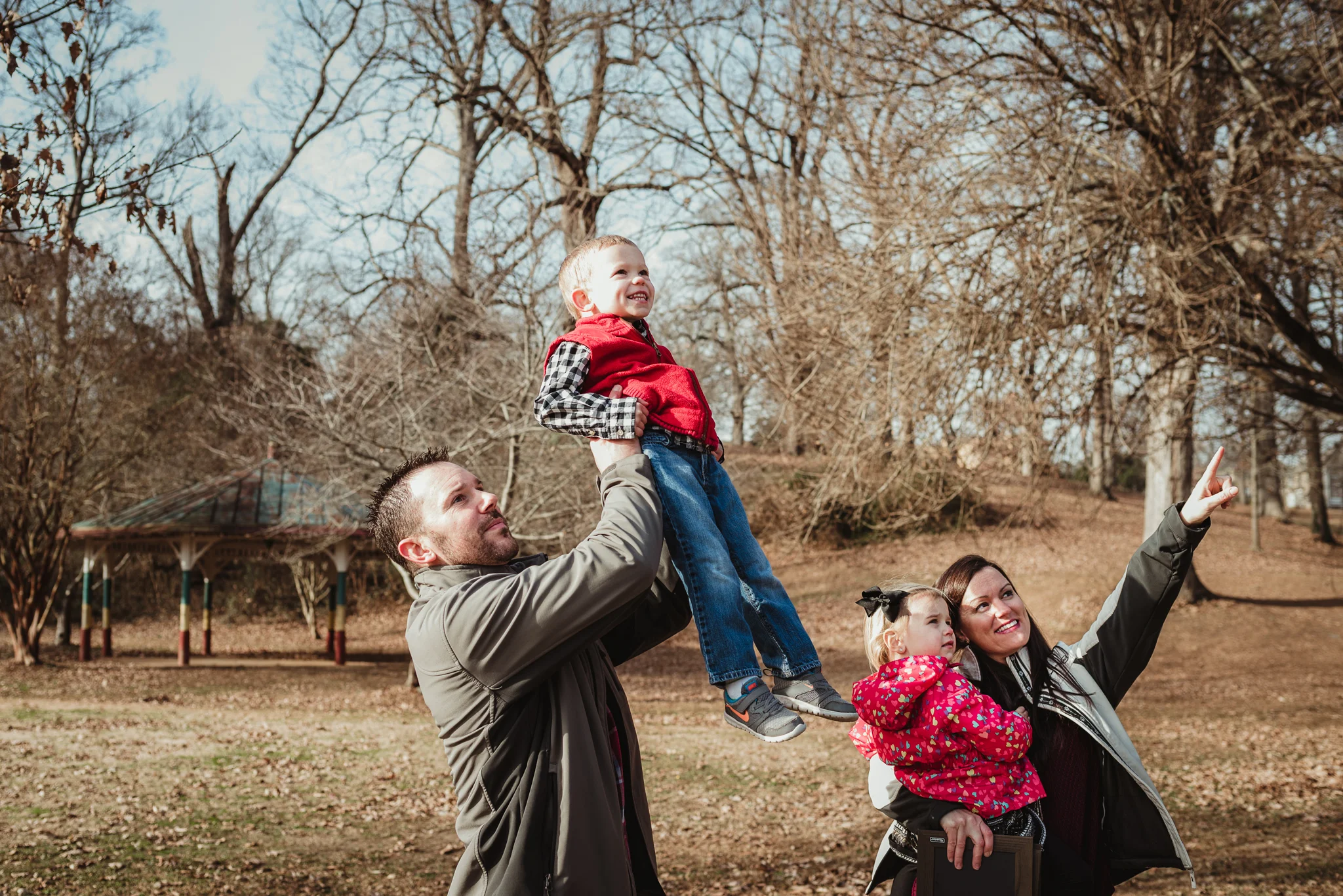 The family stares and points to the sky during their family photo session at Dorothea Dix Park in Raleigh, North Carolina.