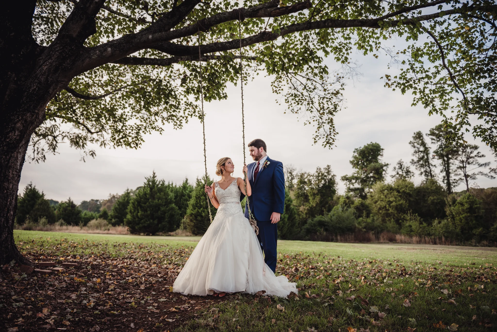 bride-sitting-on-a-swing-with-her-groom.jpg