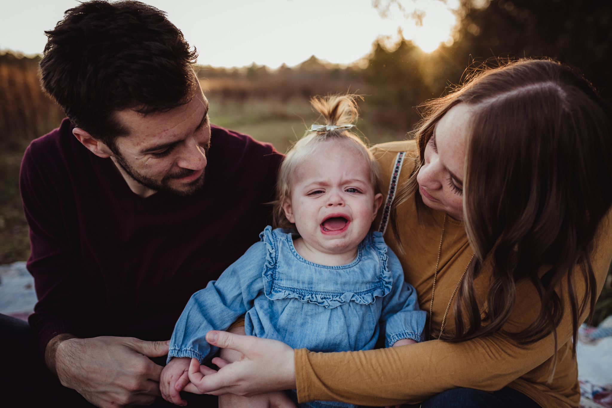 This young girl was crying during their family photo session at sunset with Rose Trail Images at Horseshoe Nature Park in Wake Forest, NC.