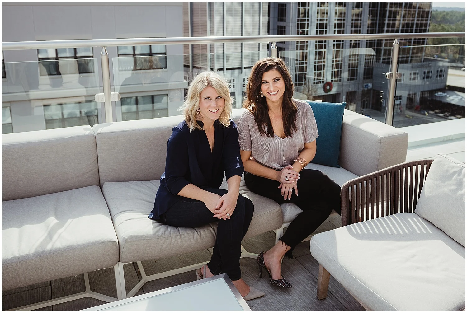 Sarah and Liz from Metro's Other Woman sit outside on the roof for headshots and branding photos with Rose Trail Images at Level7 Rooftop Bar in Raleigh, NC.