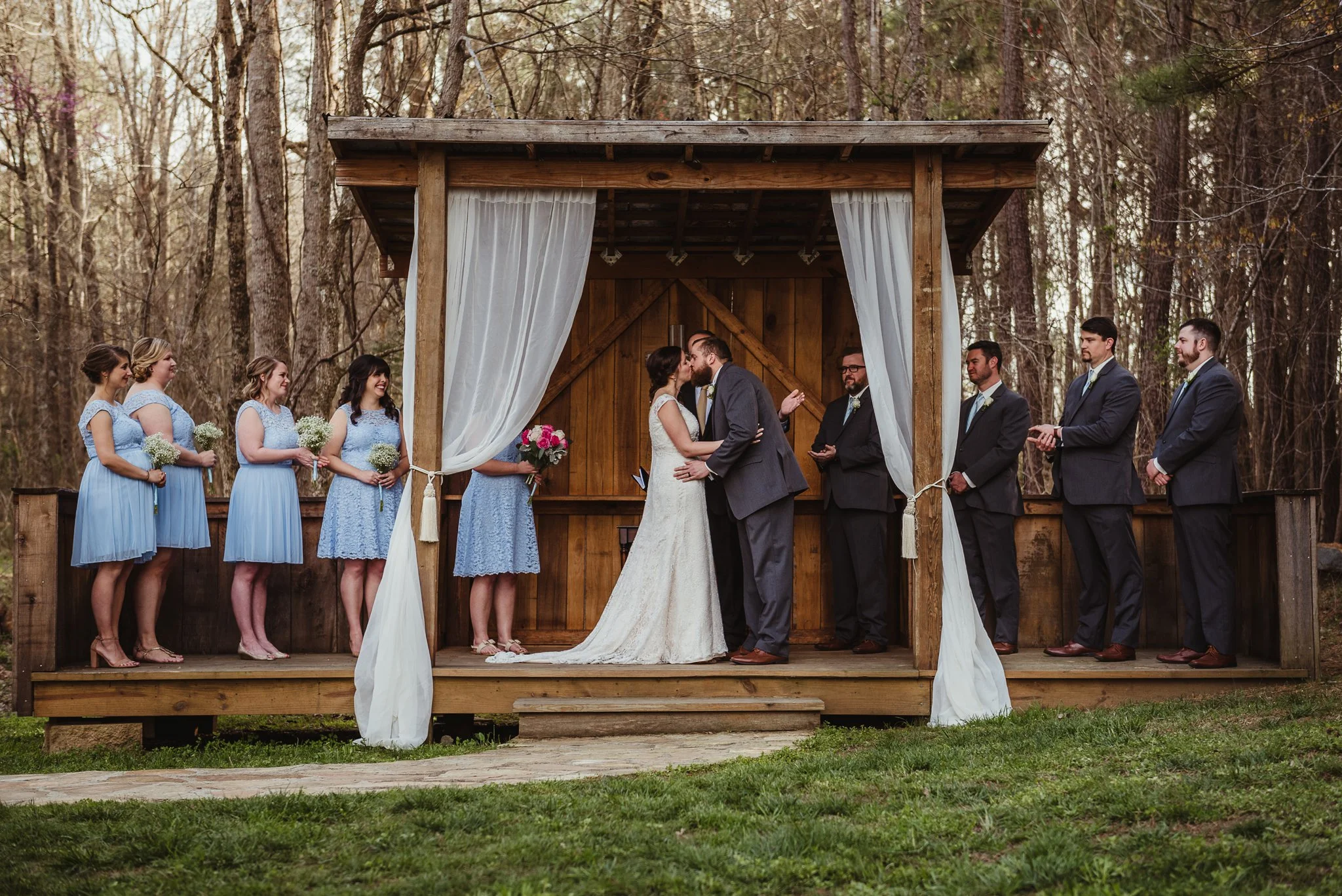 The bride and groom share a first kiss after their wedding ceremony at Carlee Farms in Oxford, NC, image taken by Rose Trail Images.