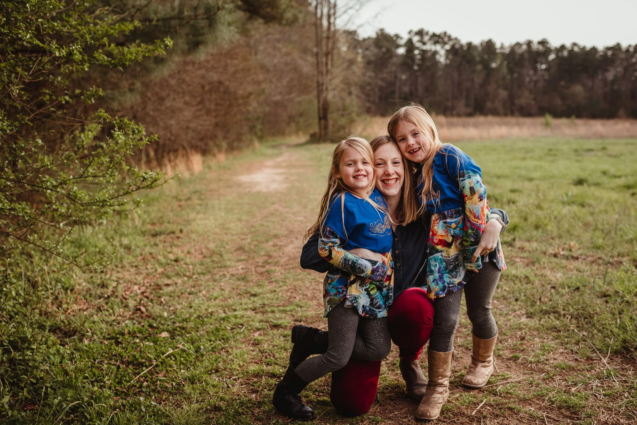 The daughters sit close with their mom during their family photo session with Rose Trail Images in Wake Forest, North Carolina.