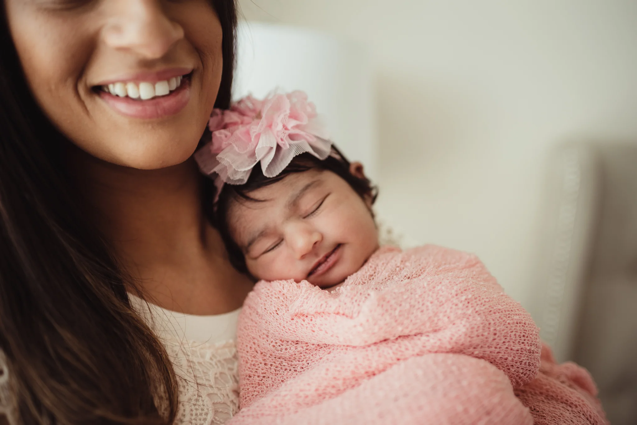Mom poses with her smiley newborn girl during their lifestyle newborn session with Rose Trail Images in Raleigh, North Carolina. 