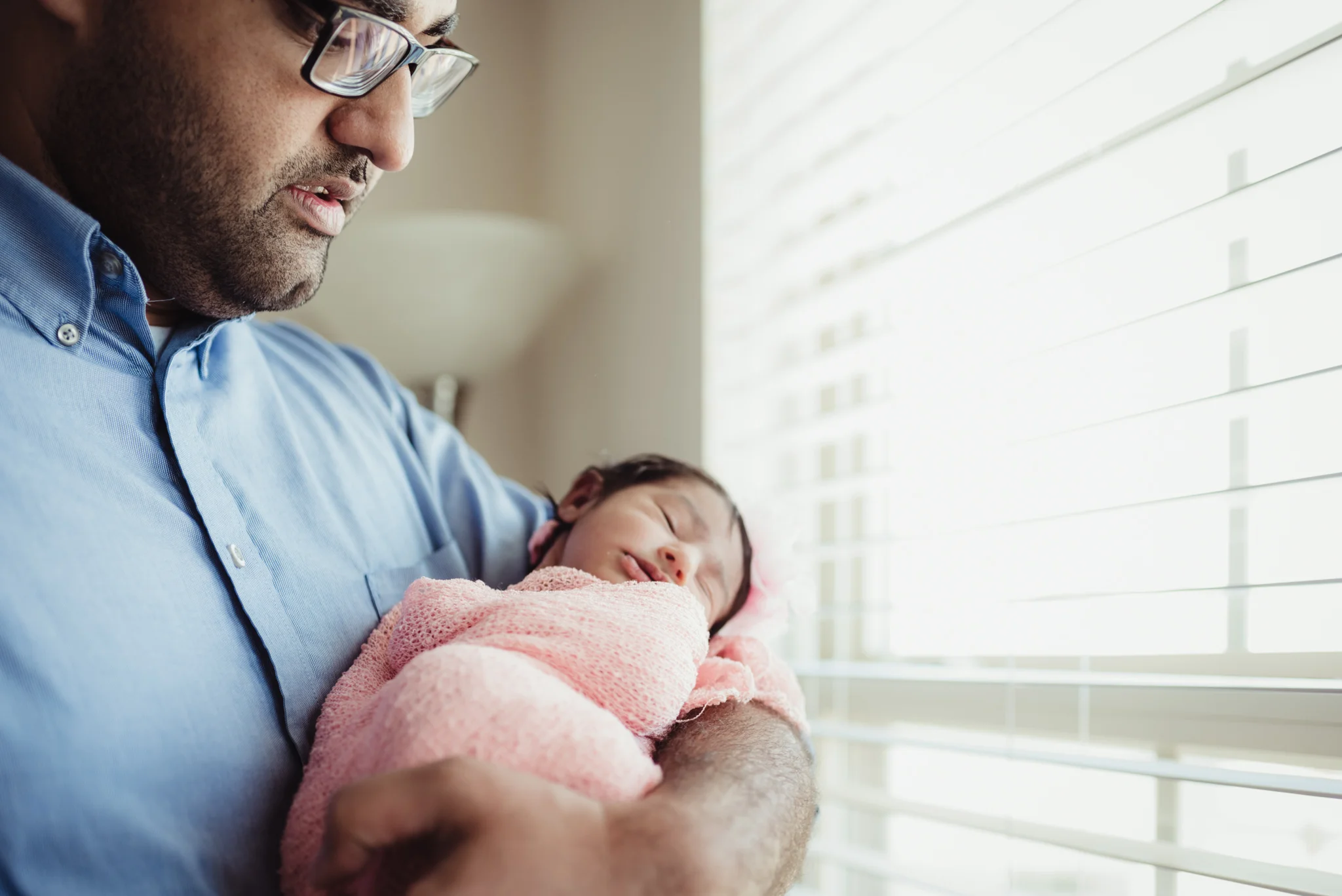 Dad holds his newborn girl during their lifestyle newborn session with Rose Trail Images in Raleigh, North Carolina. 