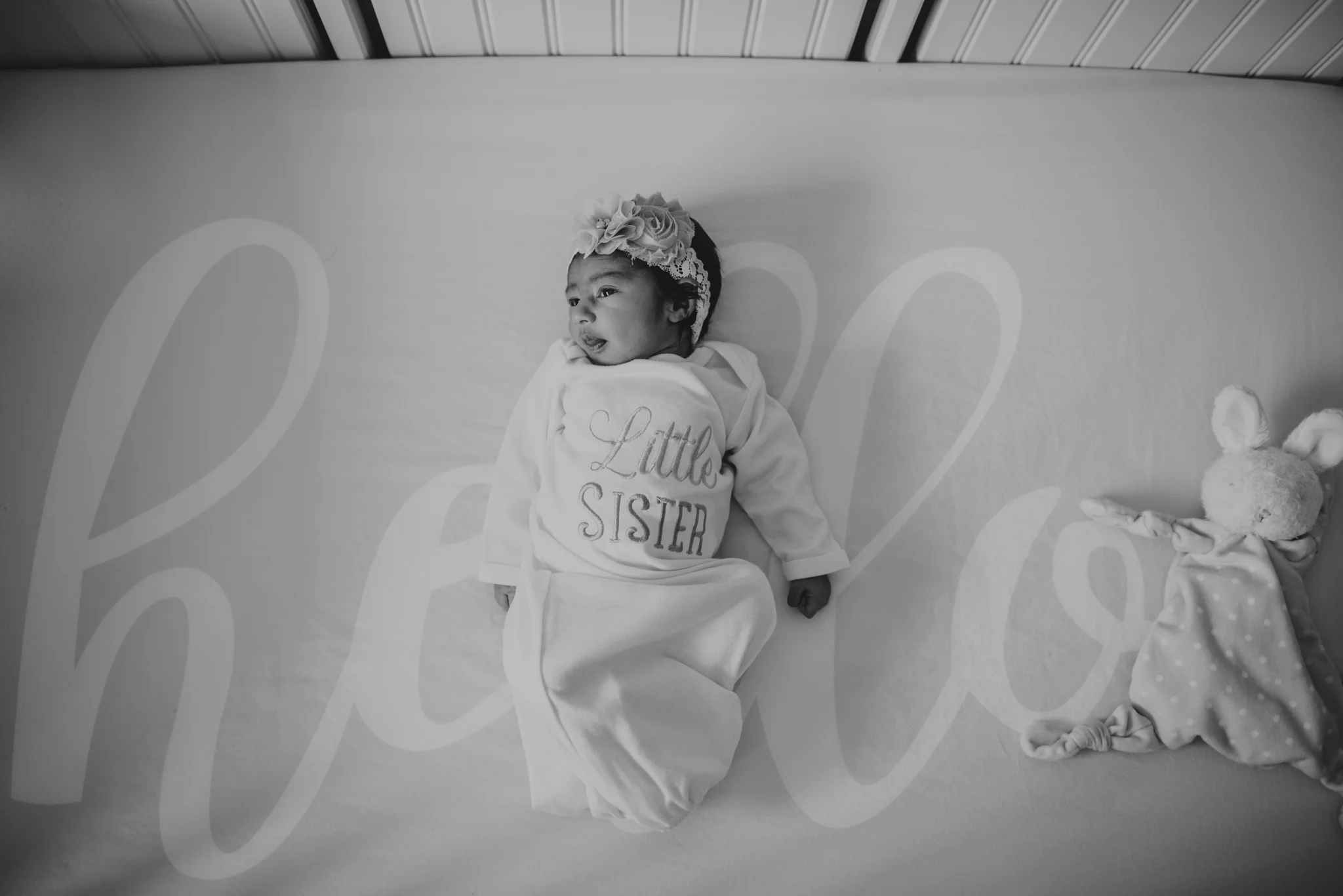 The newborn baby girl lay in her crib during her lifestyle newborn session with Rose Trail Images in Raleigh, North Carolina. 