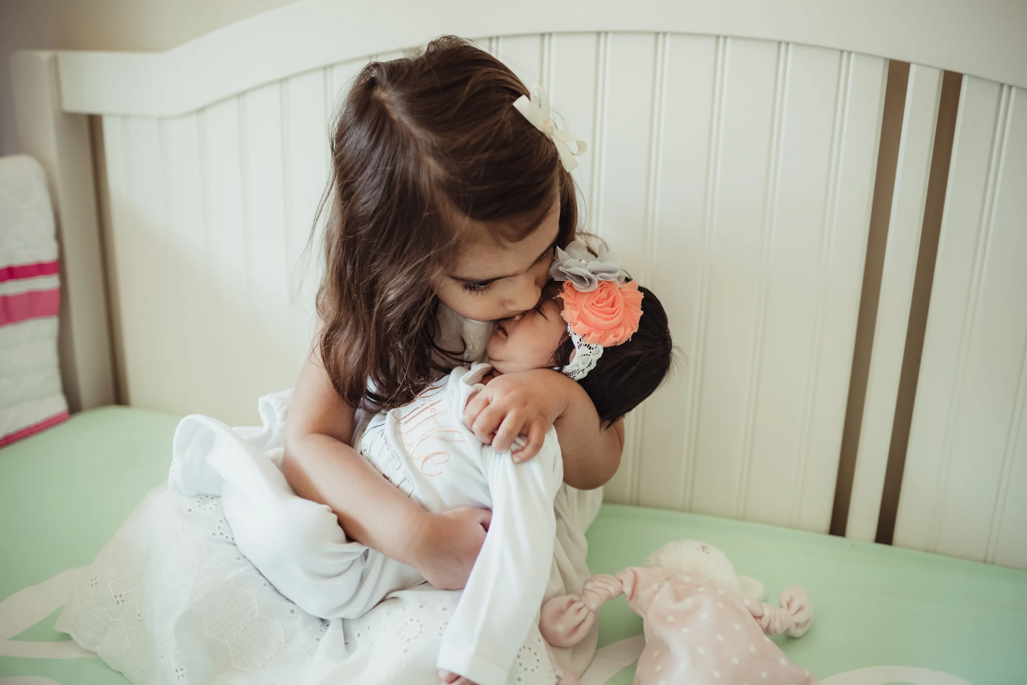 The big sister held her baby sister in the crib during her lifestyle newborn session with Rose Trail Images in Raleigh, North Carolina. 