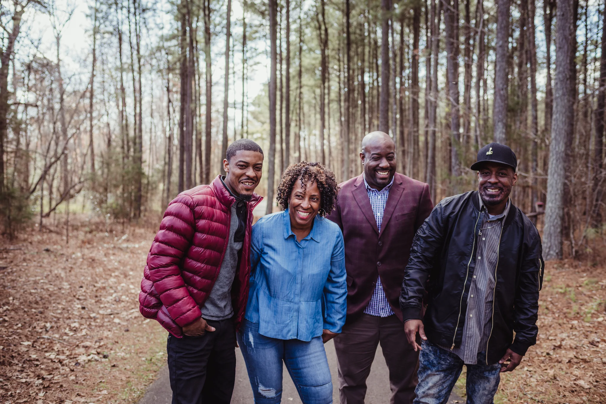 Mom and her three adult sons laugh during her family photo session with Rose Trail Images in Rolesville Main Street Park.