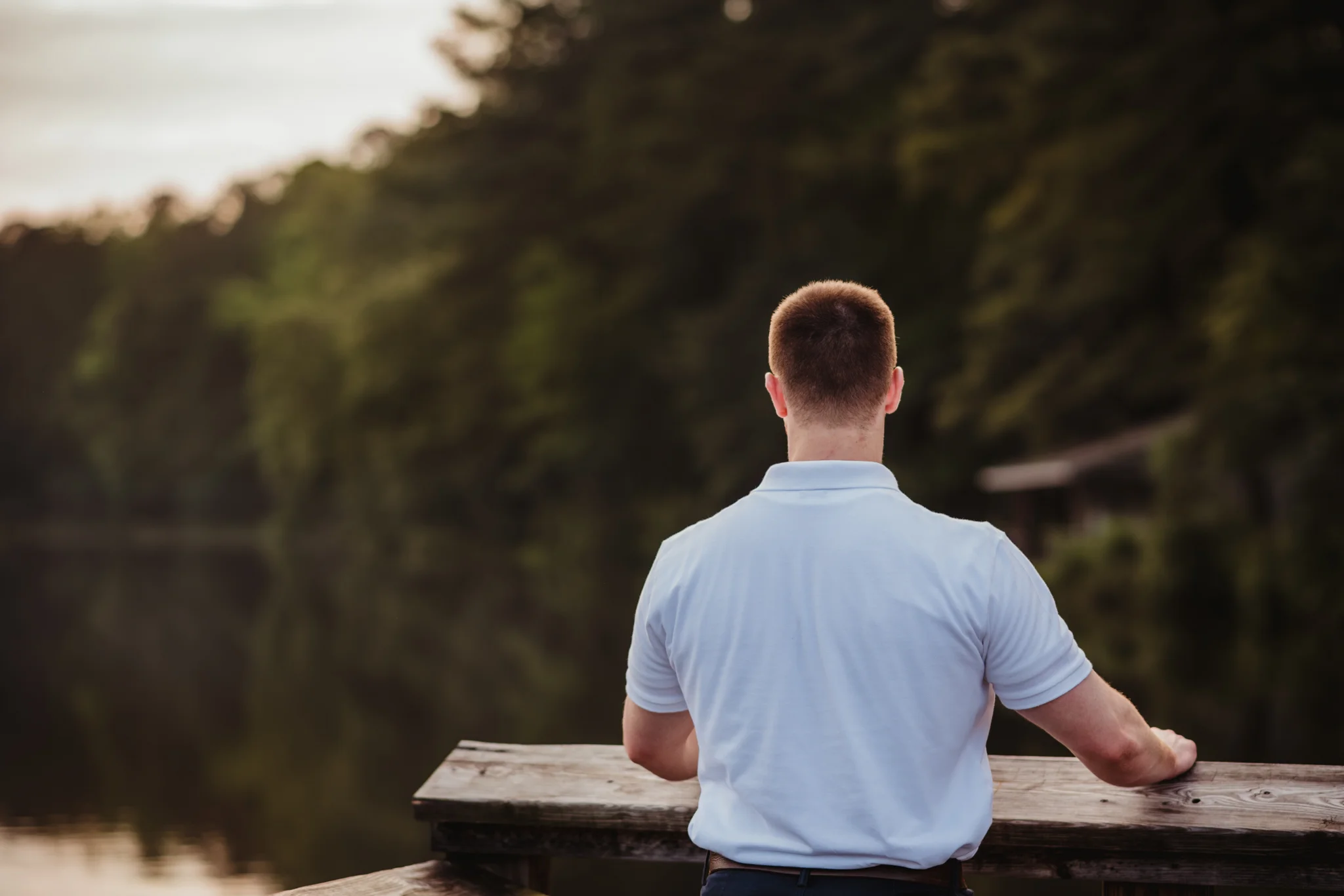 Harrison looks out at the lake during his senior portraits at Durant Nature Preserve in Raleigh, NC by Rose Trail Images.