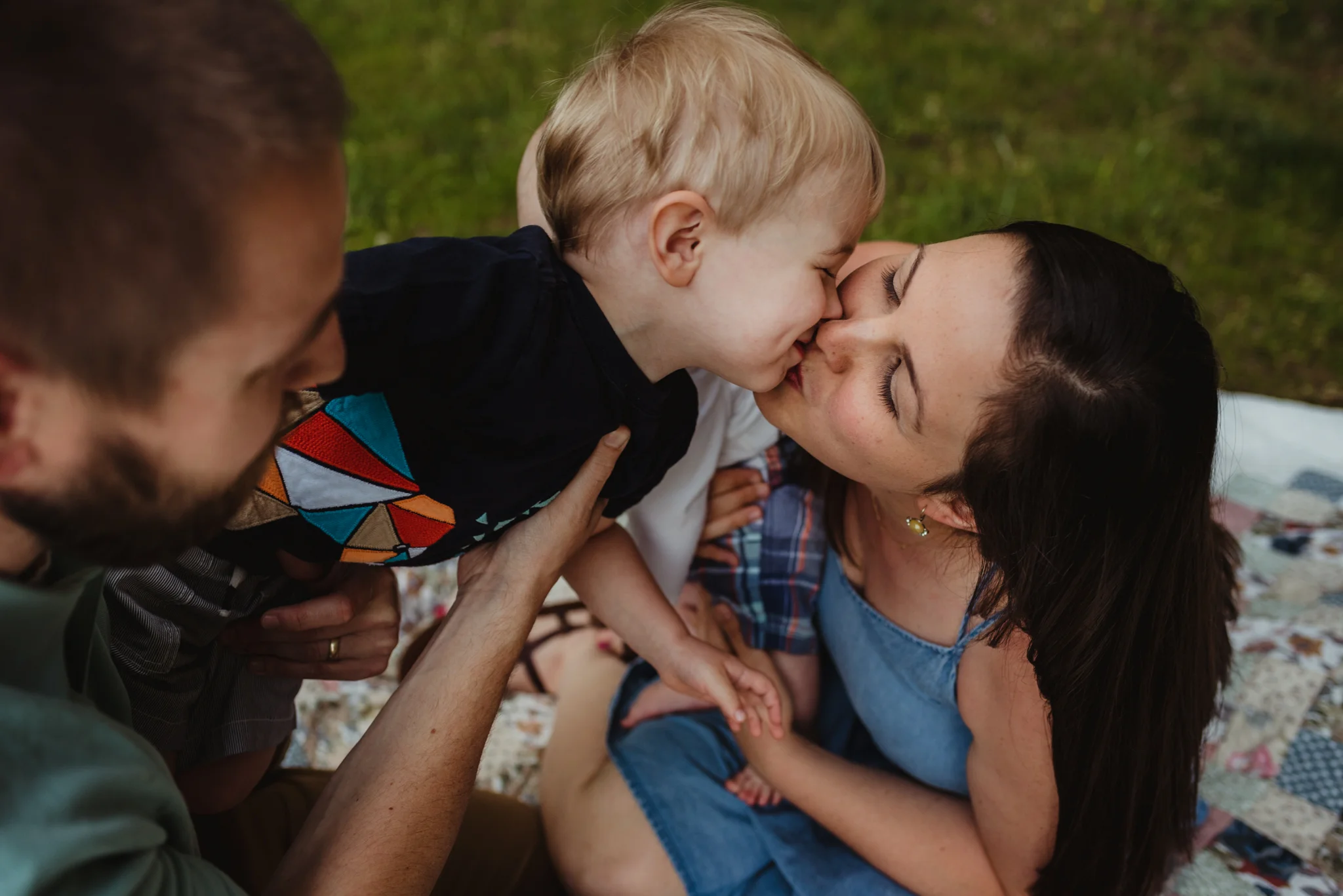 Older brother kisses Mommy during their family photo session with Rose Trail Images in Rolesville, North Carolina.