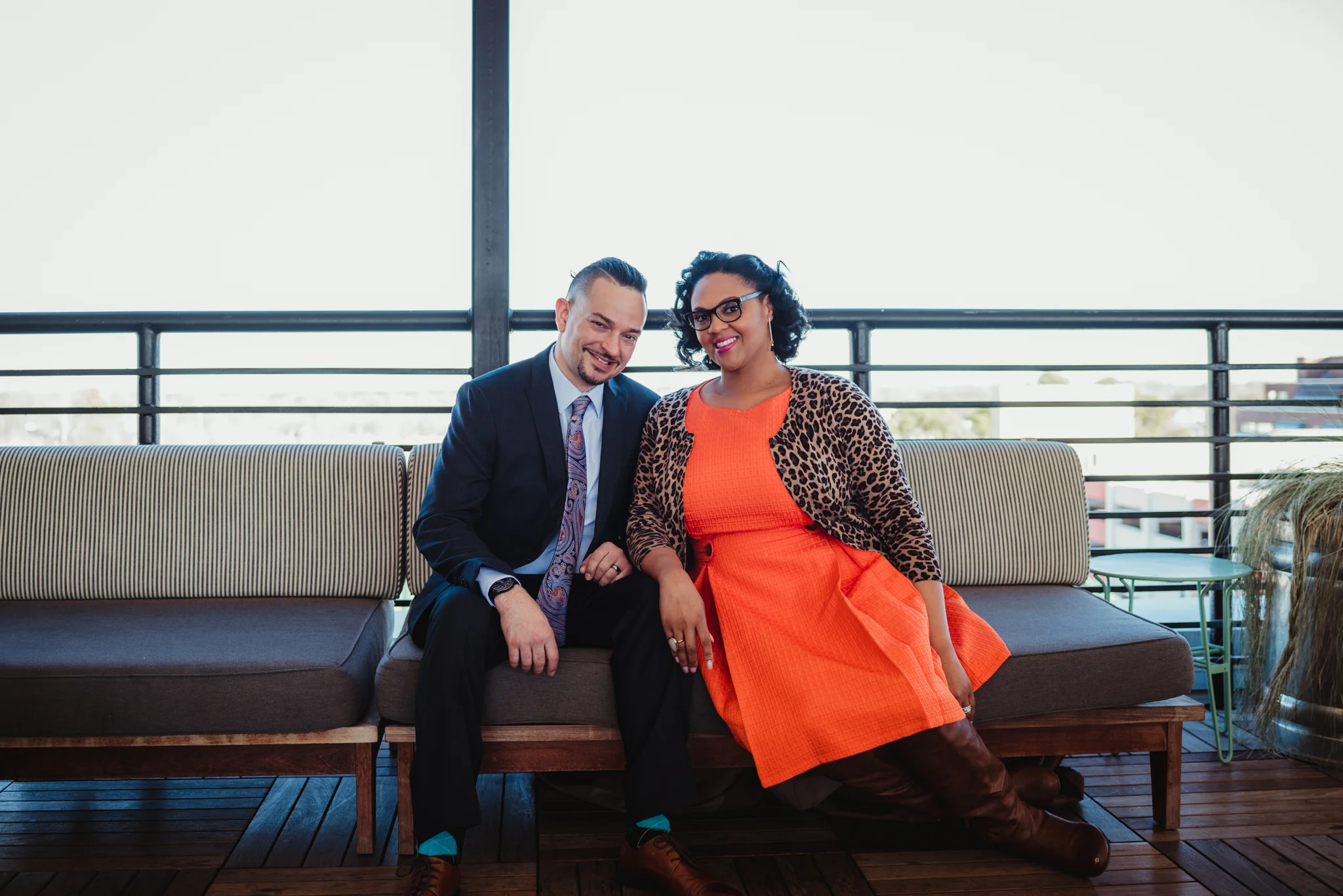 The husband and wife pose together on the bench for Rose Trail Images on the rooftop of the Durham Hotel in Durham, North Carolina.