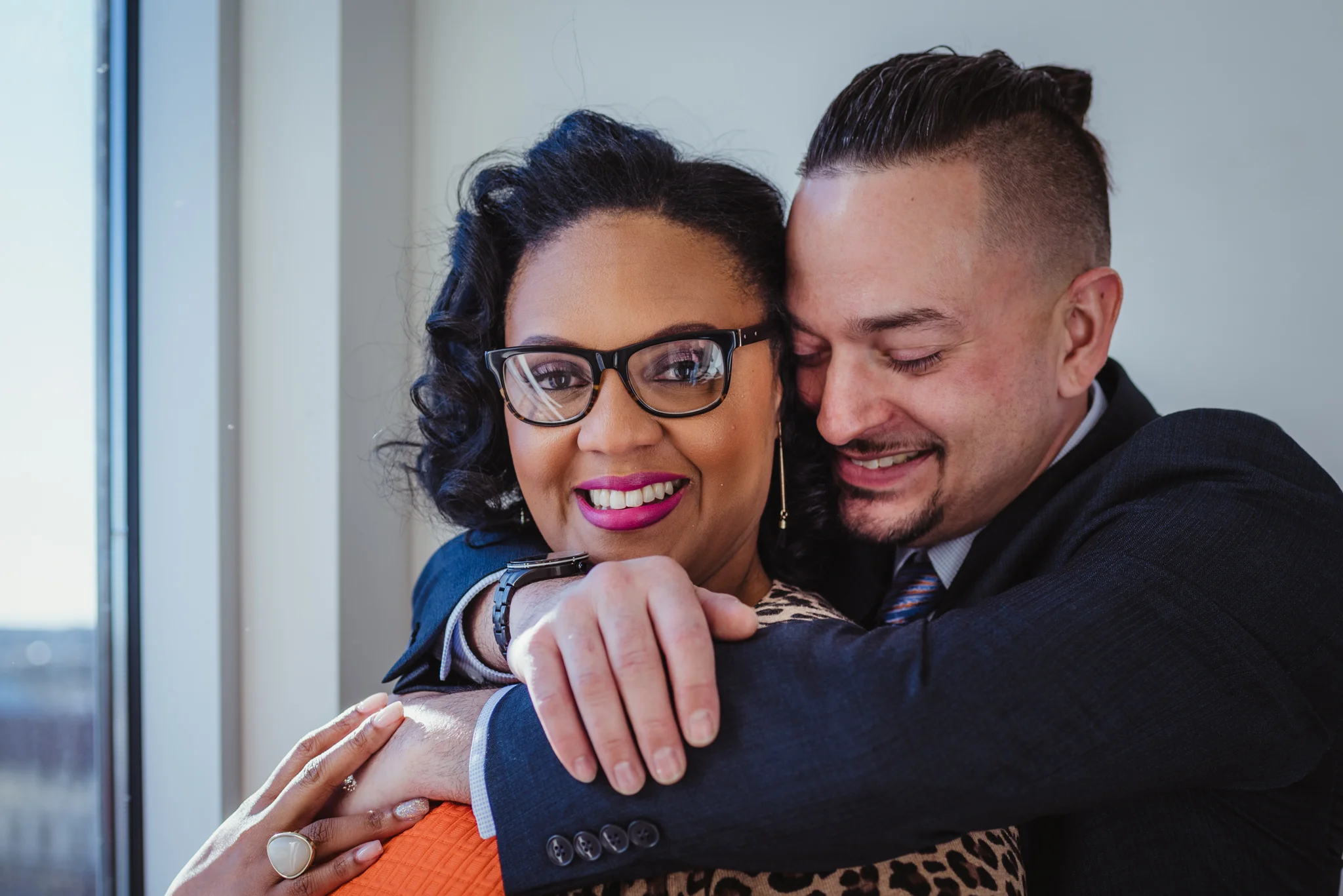 The husband hugs his wife for Rose Trail Images near the elevator of the Durham Hotel in Durham, North Carolina.