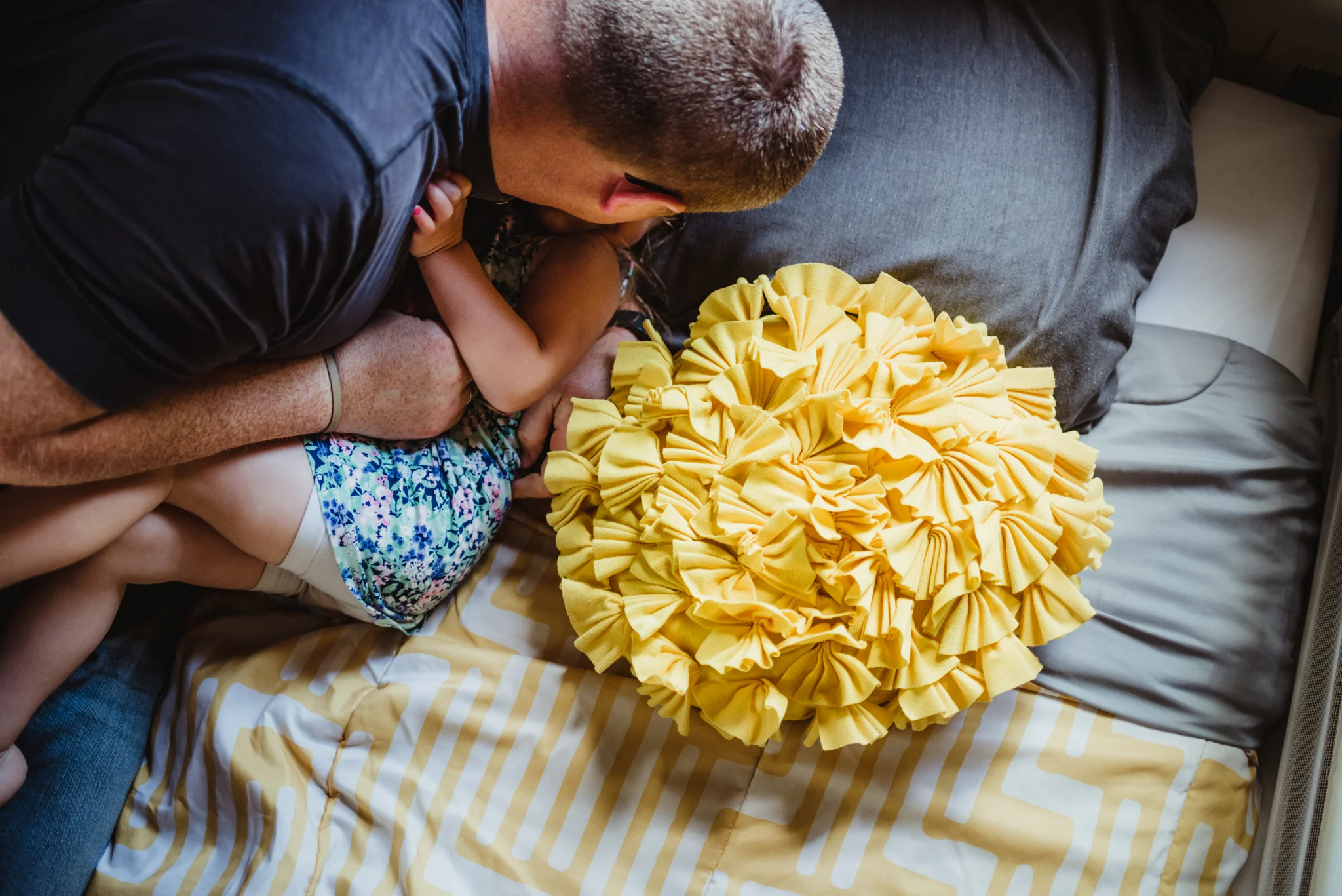 The Dad tickles the little girl on her bed during their lifestyle session at home in Wake Forest with Rose Trail Images.