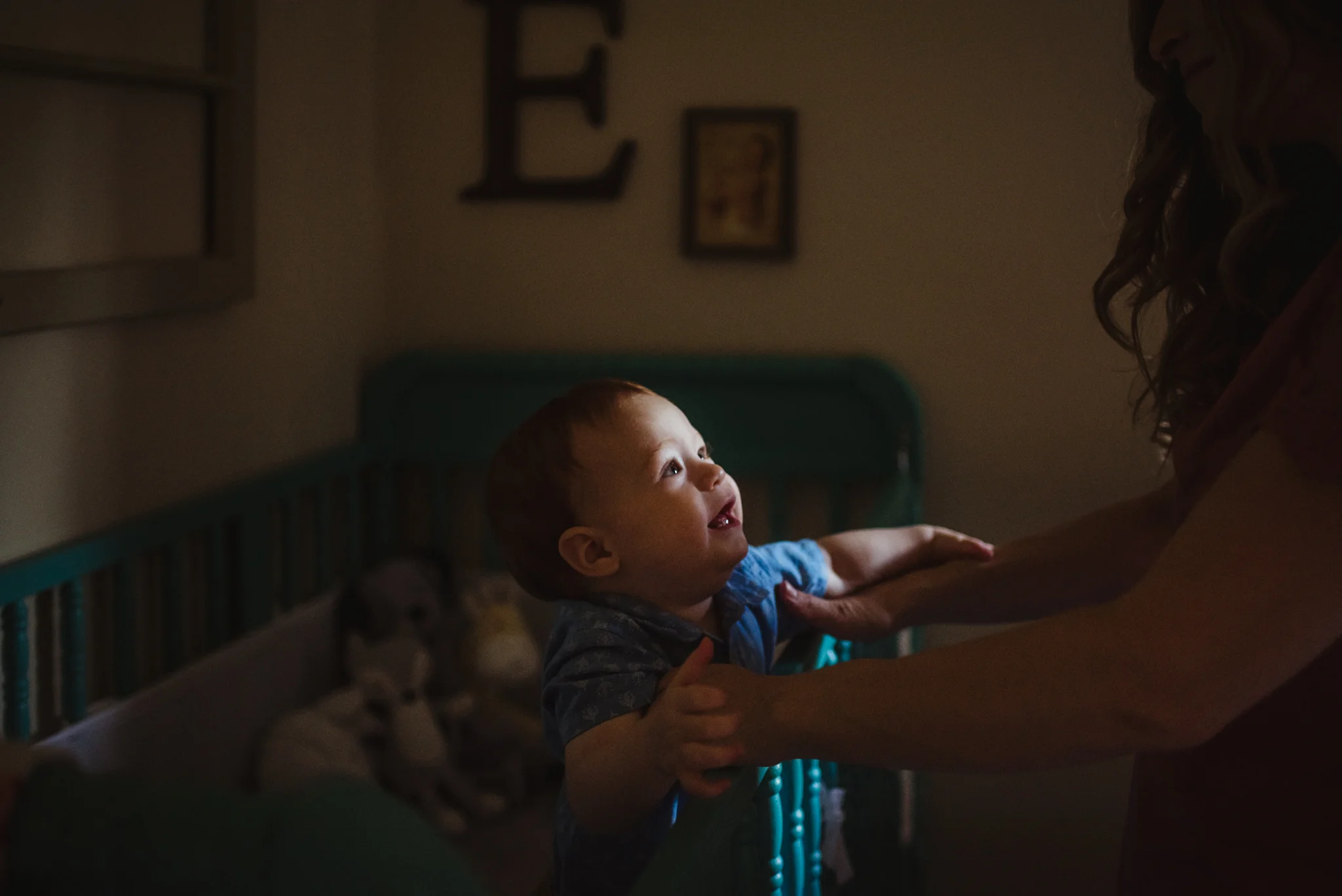 The baby reaches for Mom in his crib during their lifestyle session at home in Wake Forest with Rose Trail Images.