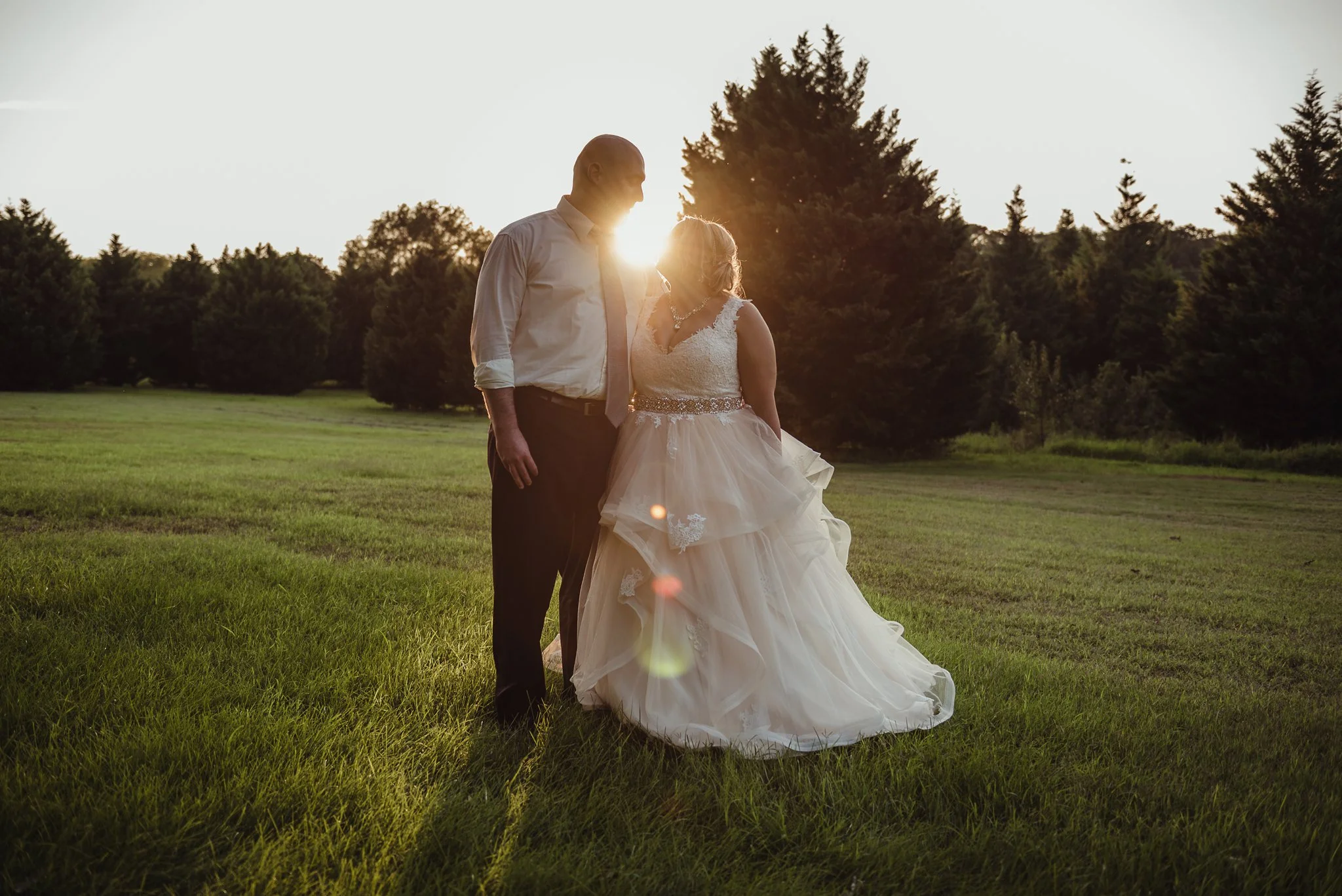 The bride and groom hold each other at sunset during their wedding day in Raleigh, photo by Rose Trail Images.